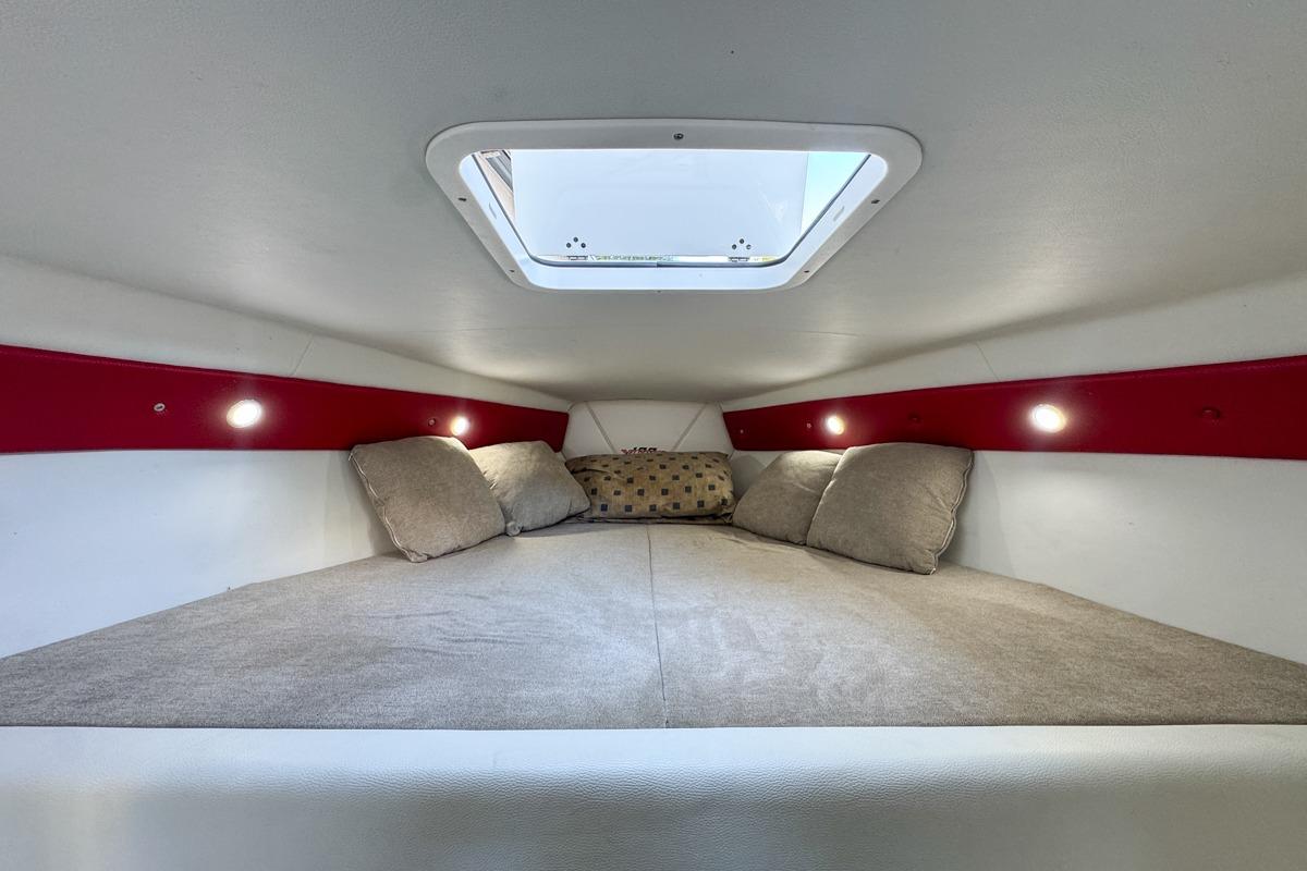 Cozy interior cabin of 2022 Velocity 290sc boat with skylight and cushions.