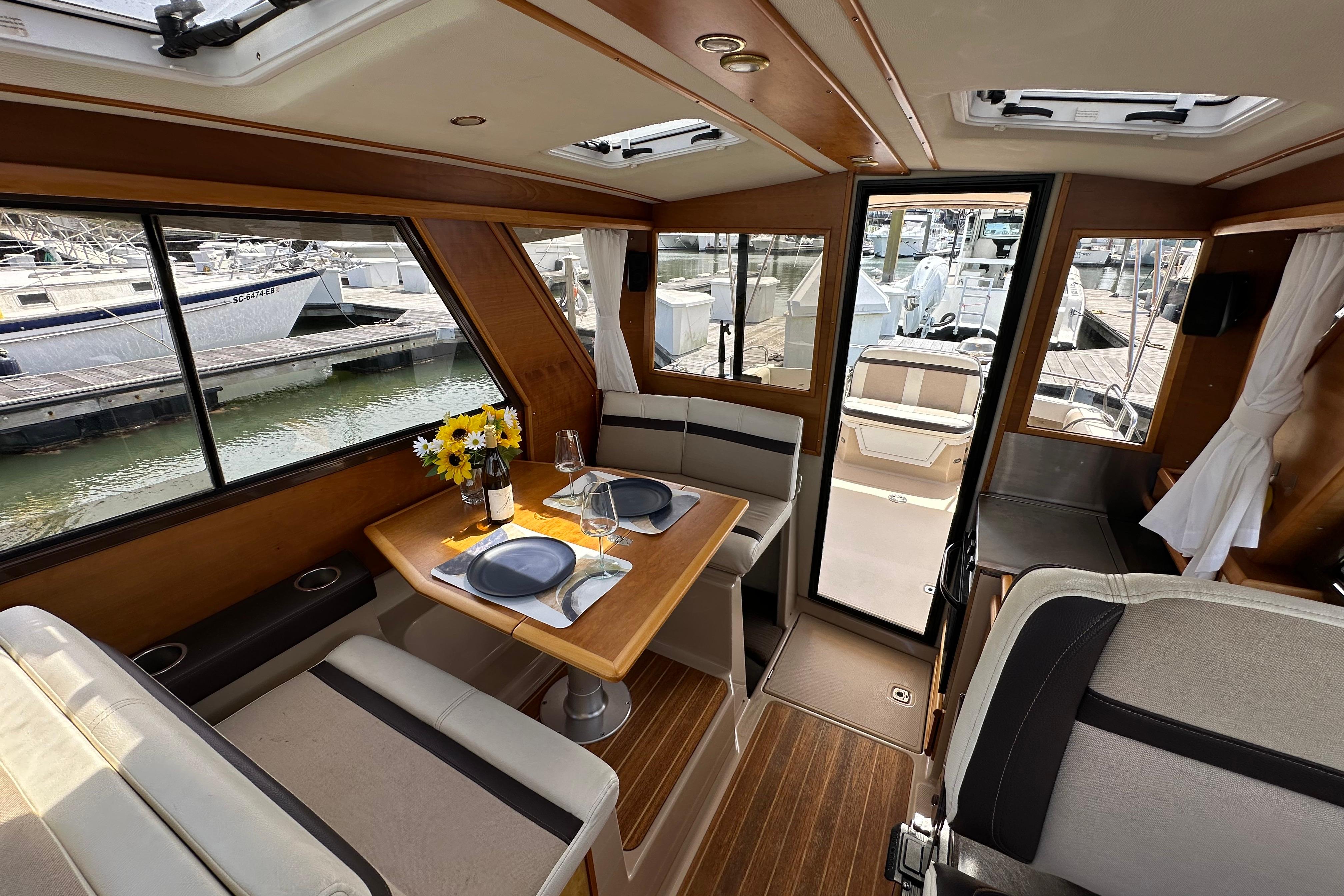 Interior of a 2016 Cutwater C-28 LE boat with dining area and marina view.