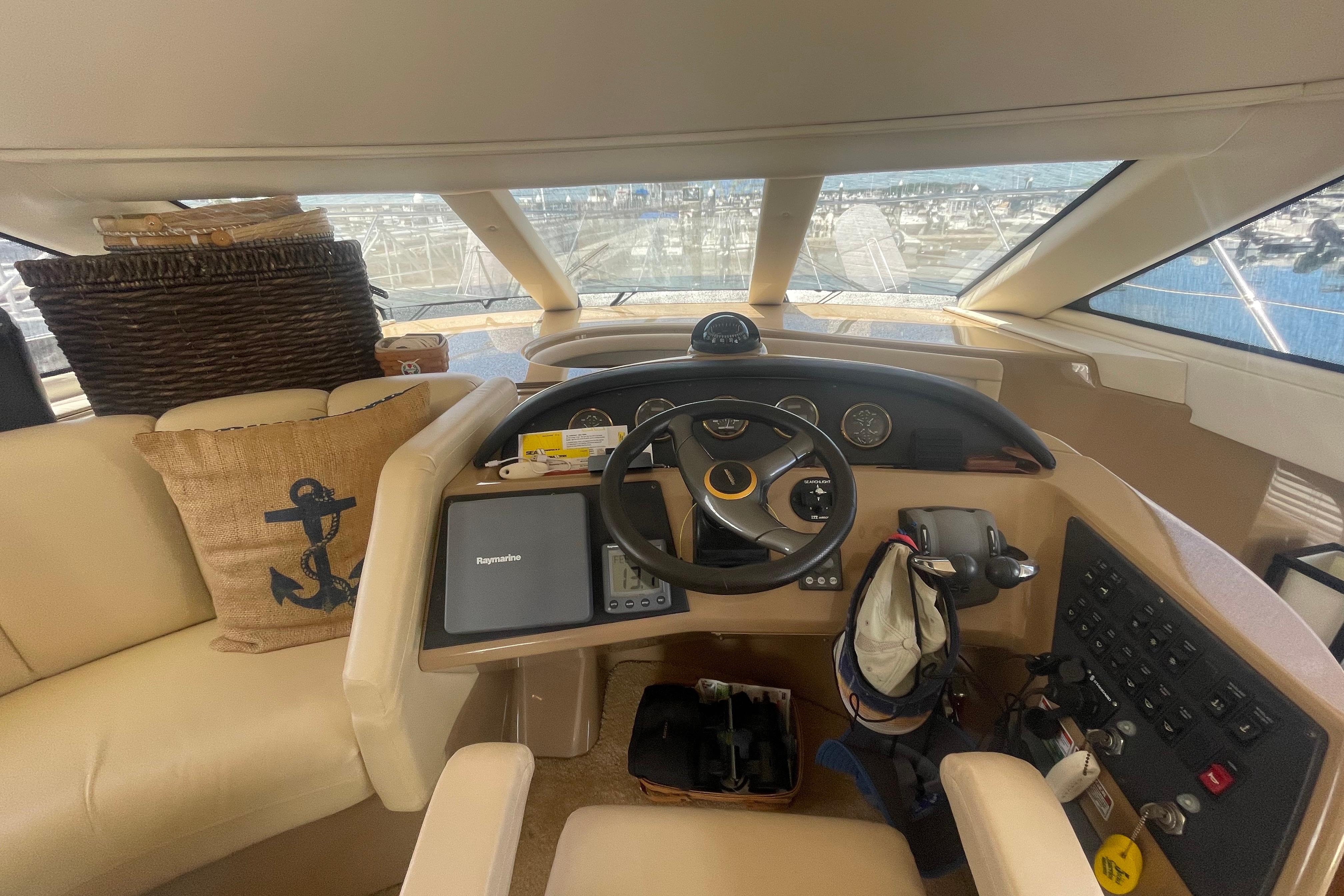 Interior helm of 2002 Carver 410 Sport Sedan yacht with steering wheel and navigation equipment.