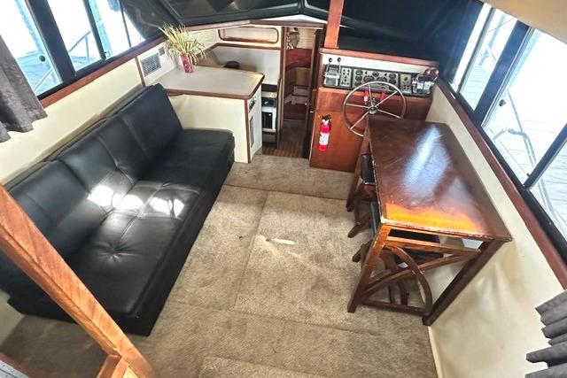 Interior of 1989 Carver 32 Aft Cabin Motor Yacht with sofa and helm station.