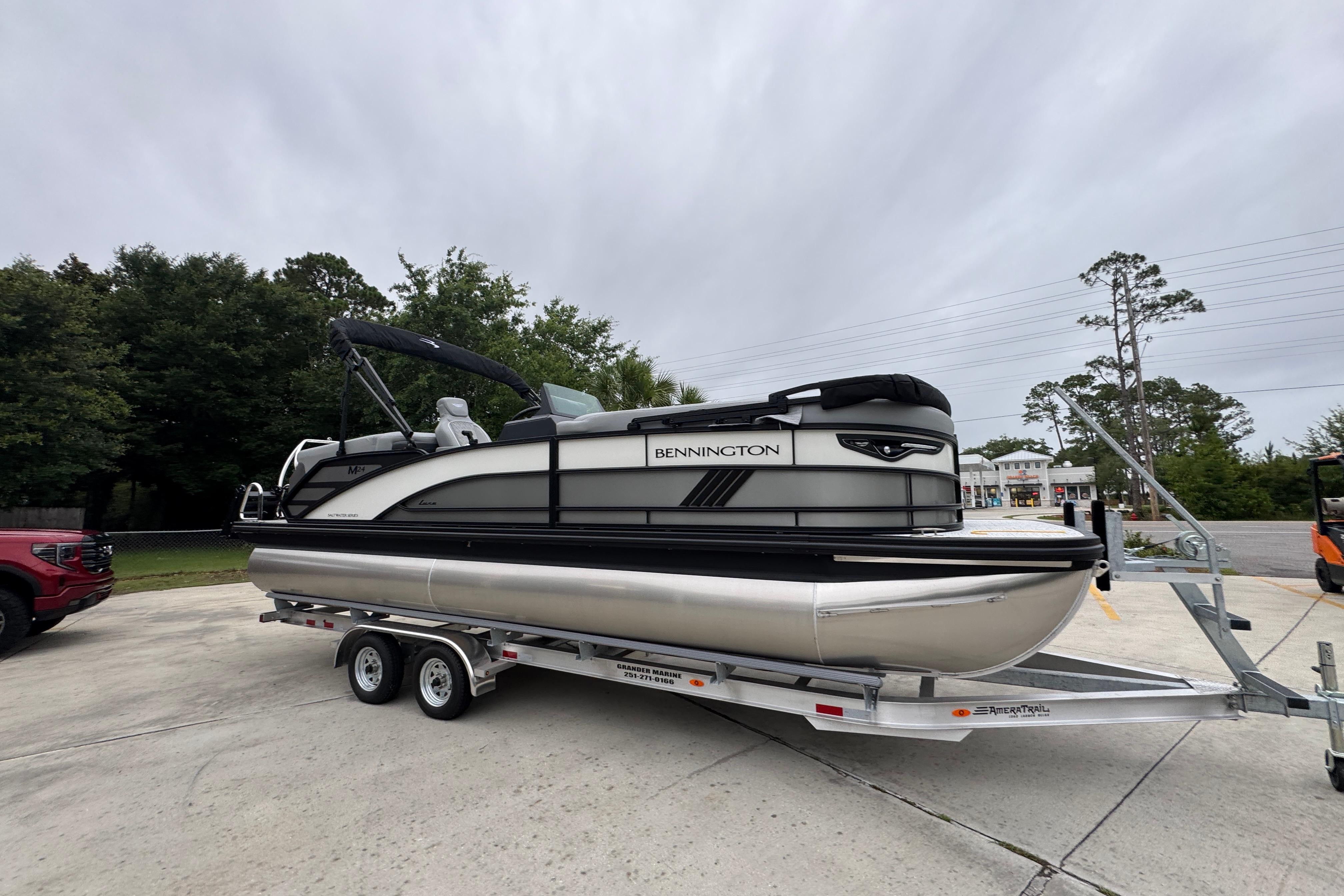 2027 Bennington 24 MFB pontoon boat on trailer, parked outdoors.