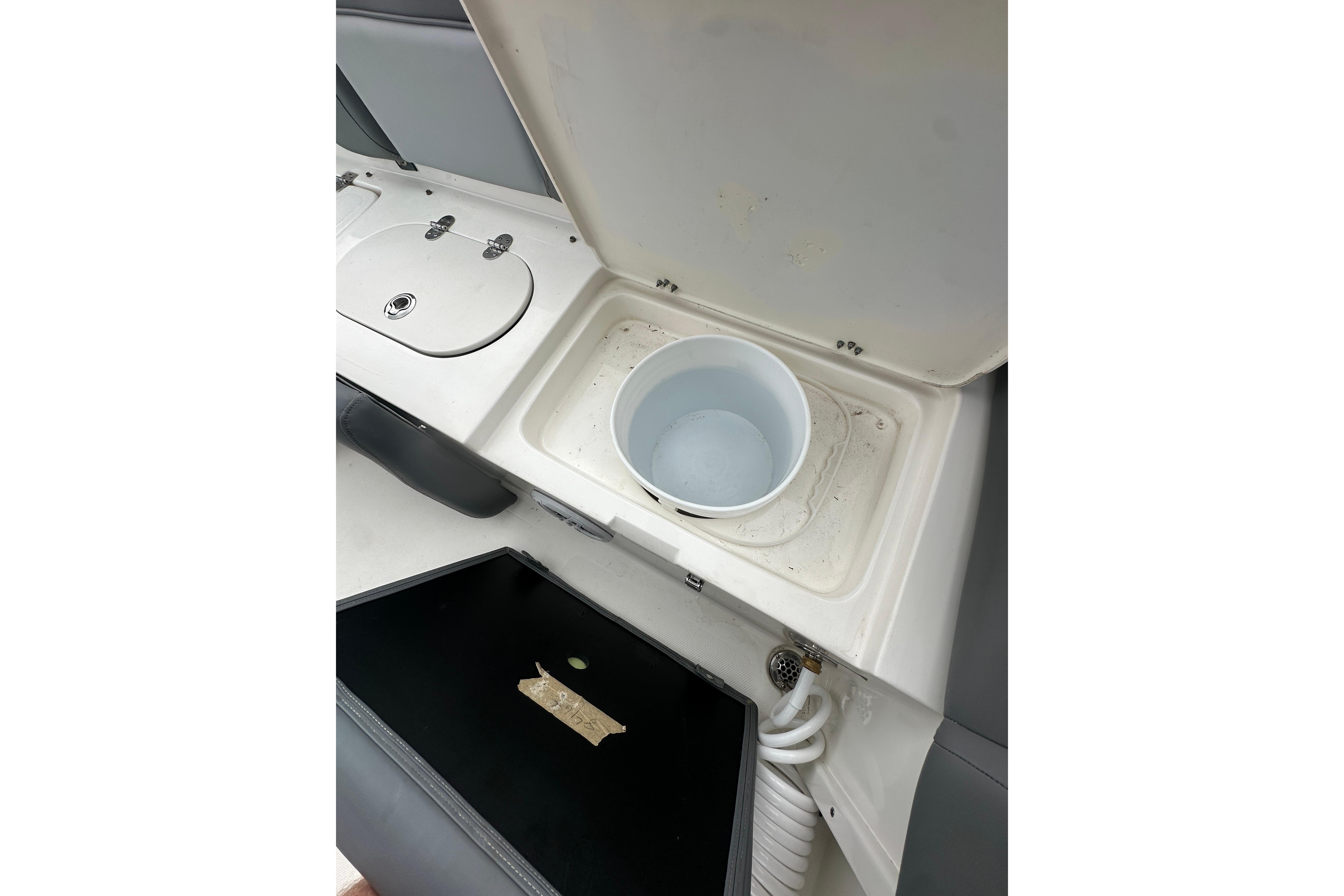 2023 NauticStar 2102 Legacy boat interior with storage compartments and bucket.
