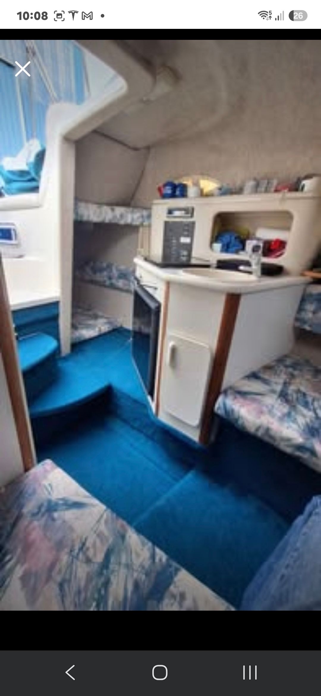 Interior of the 1998 Sea Ray 240 Sundancer with blue carpeting and seating.