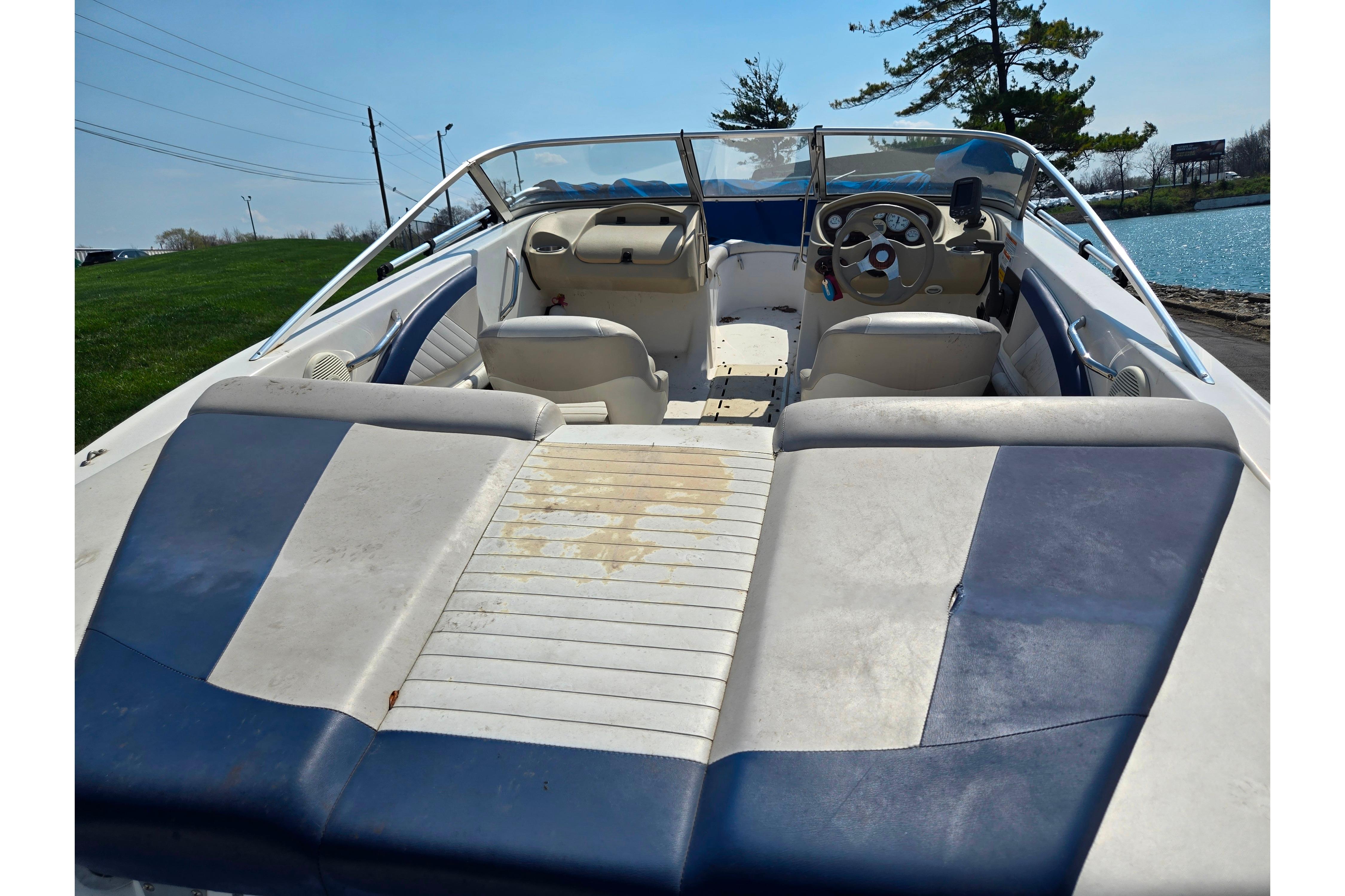 2007 Glastron GT 185 boat interior with blue and white seating, steering wheel, and open deck.