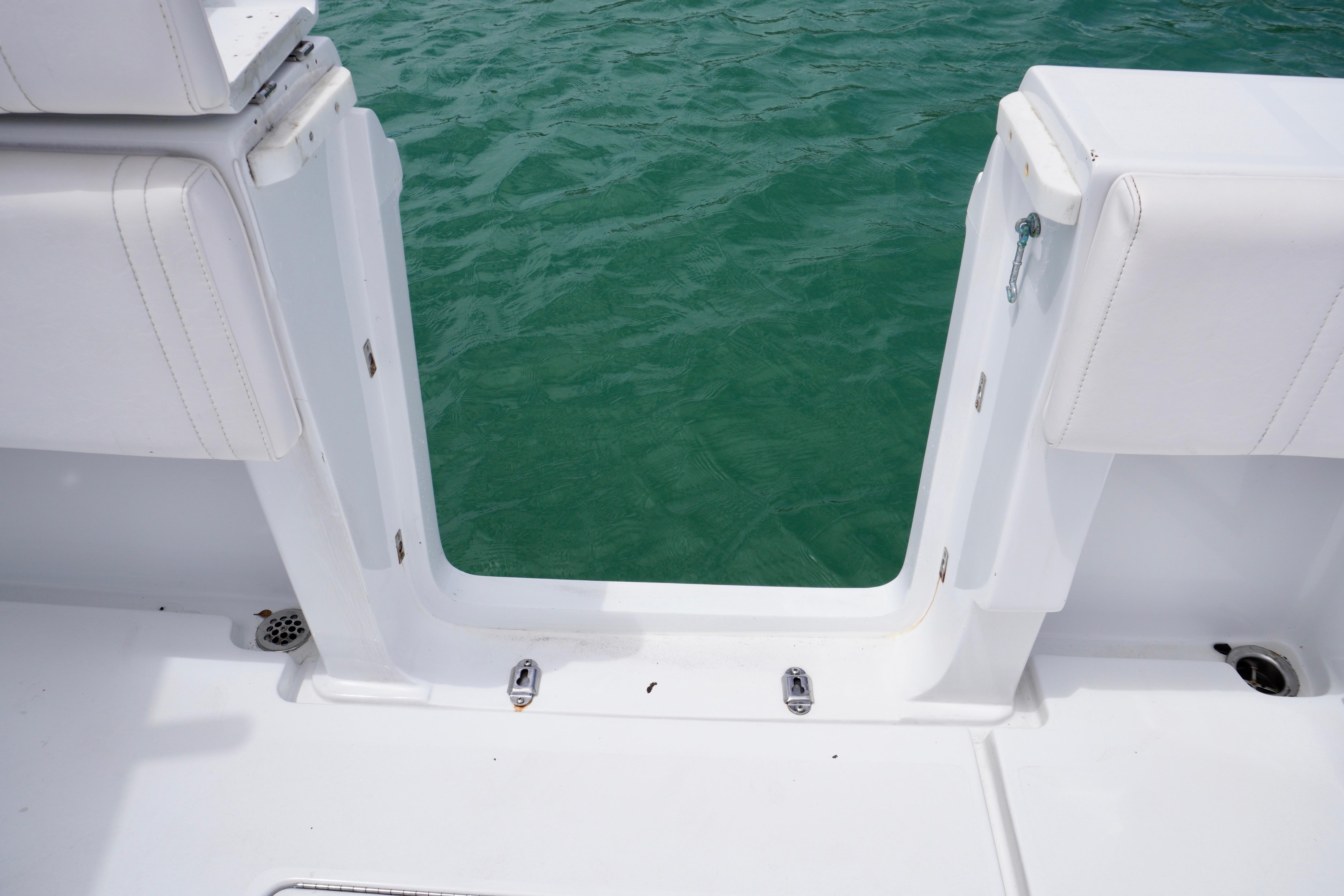 Contender 35 LS 2013 boat with open transom door, overlooking green water.