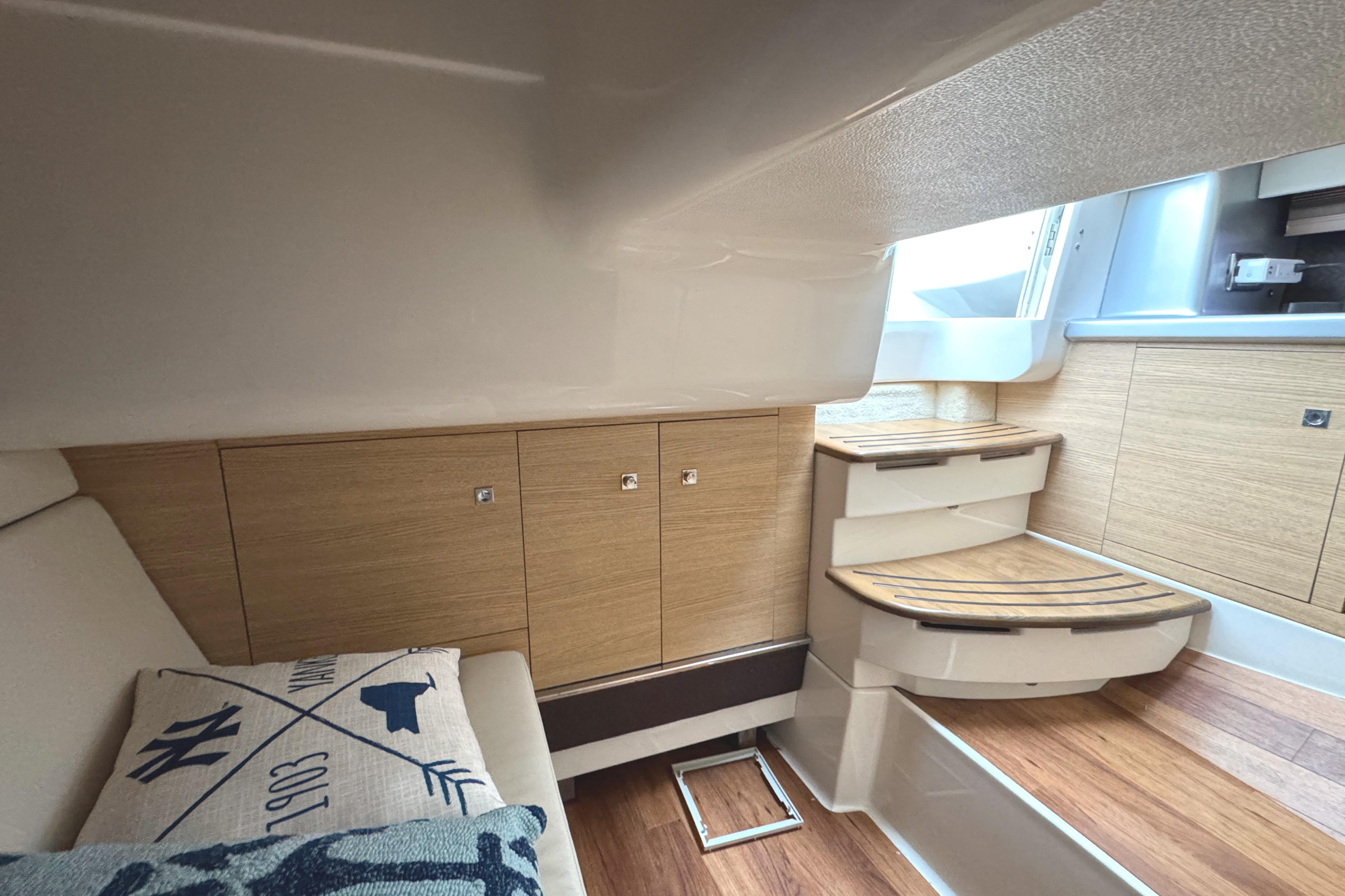 Interior of 2012 Chaparral 327 SSX boat with wooden cabinetry and seating area.