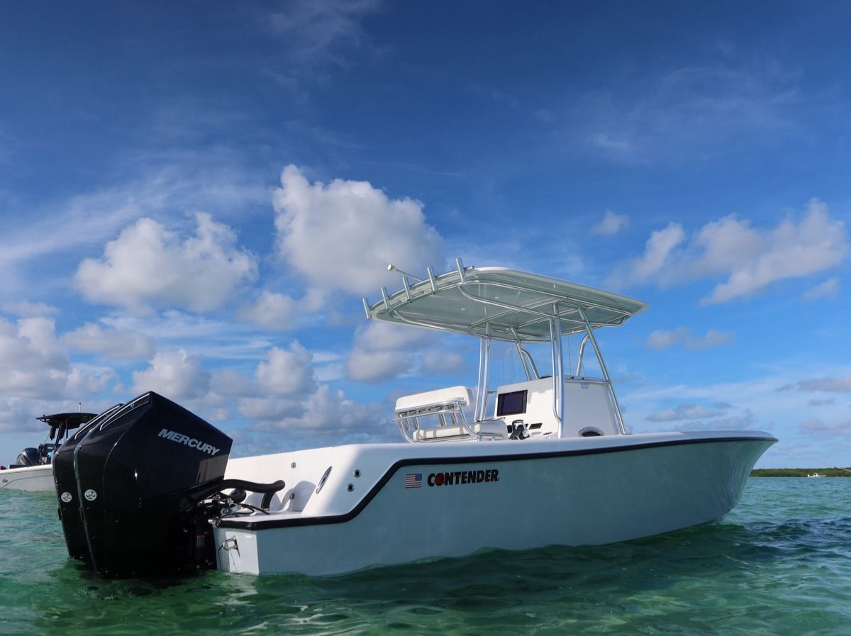A Contender 28 Tournament boat on clear water under a blue sky.
