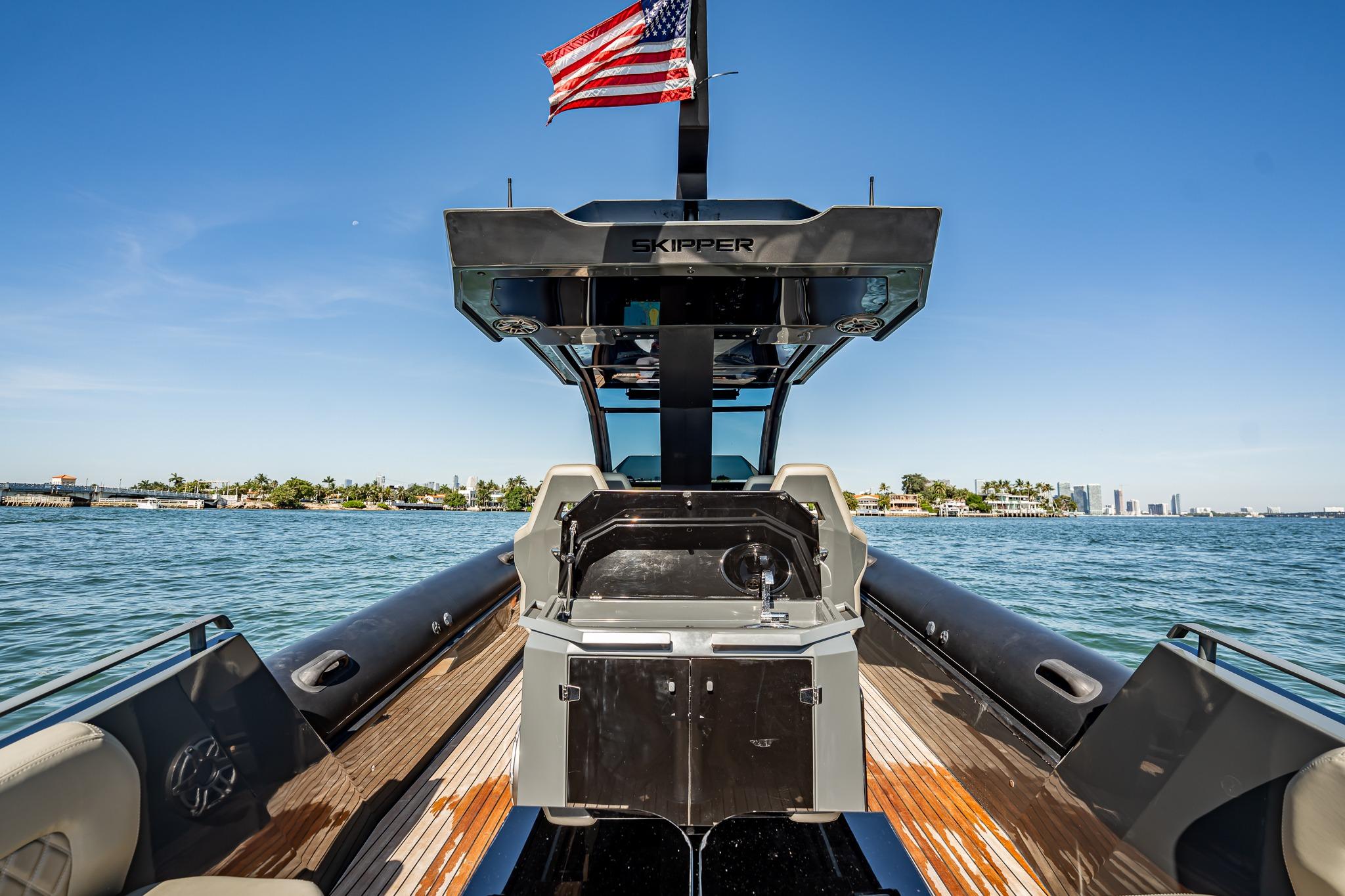 2023 Skipper-BSK 38NC boat with American flag, cruising on a sunny day.