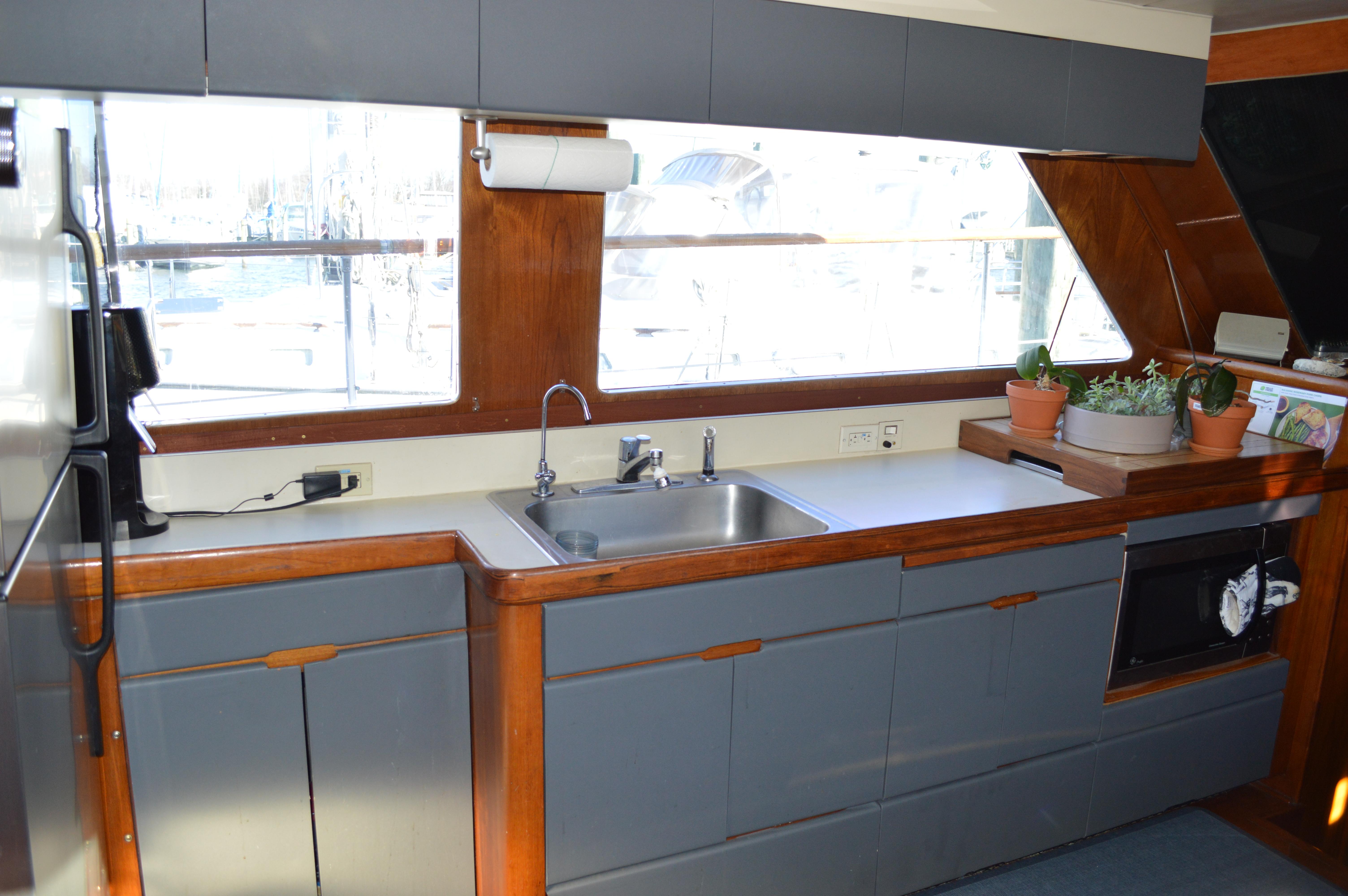 1986 Gulfstar 49 Motor Yacht kitchen with sink, cabinets, and large windows.