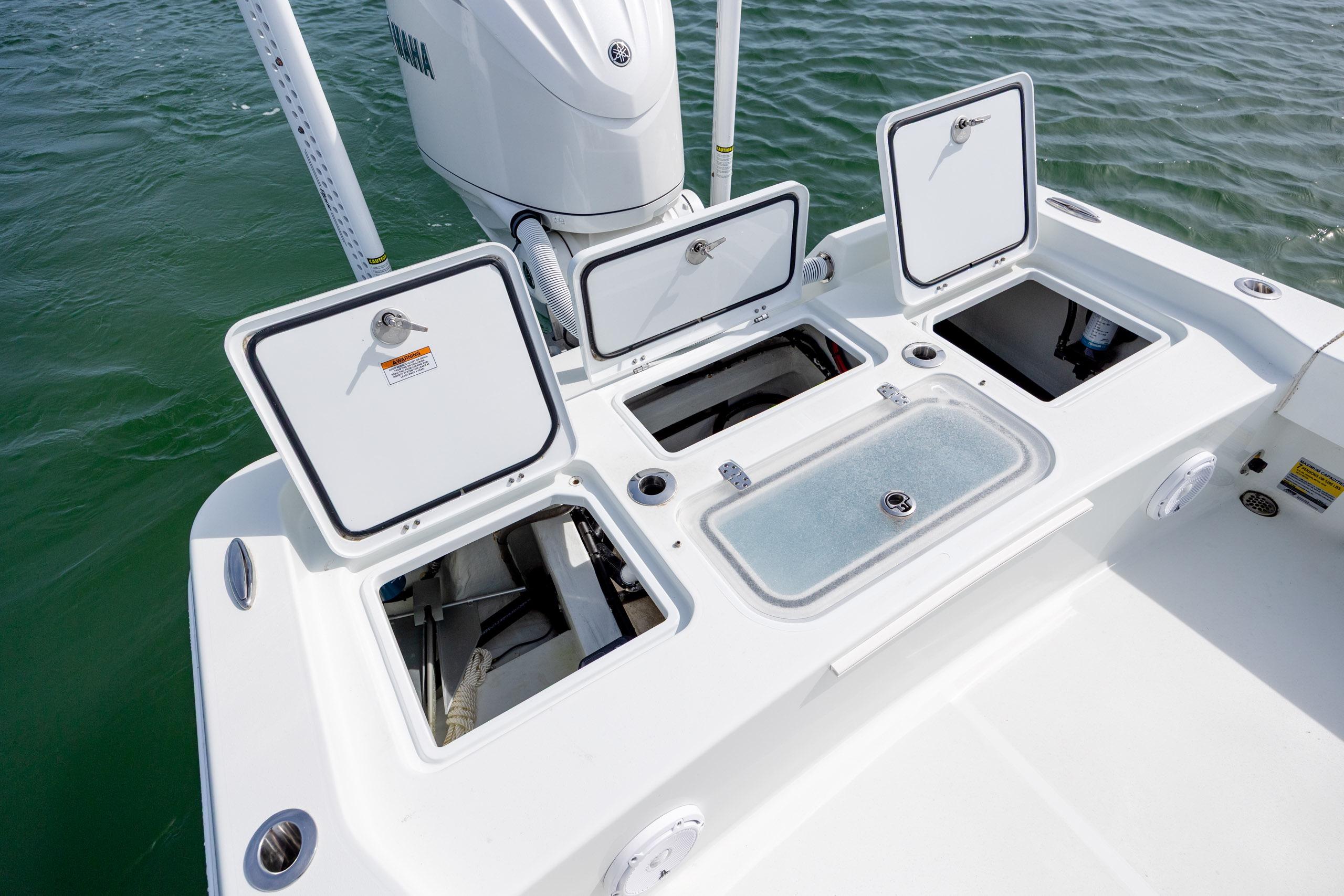 2024 Contender 23 Bay boat with open storage compartments on deck.