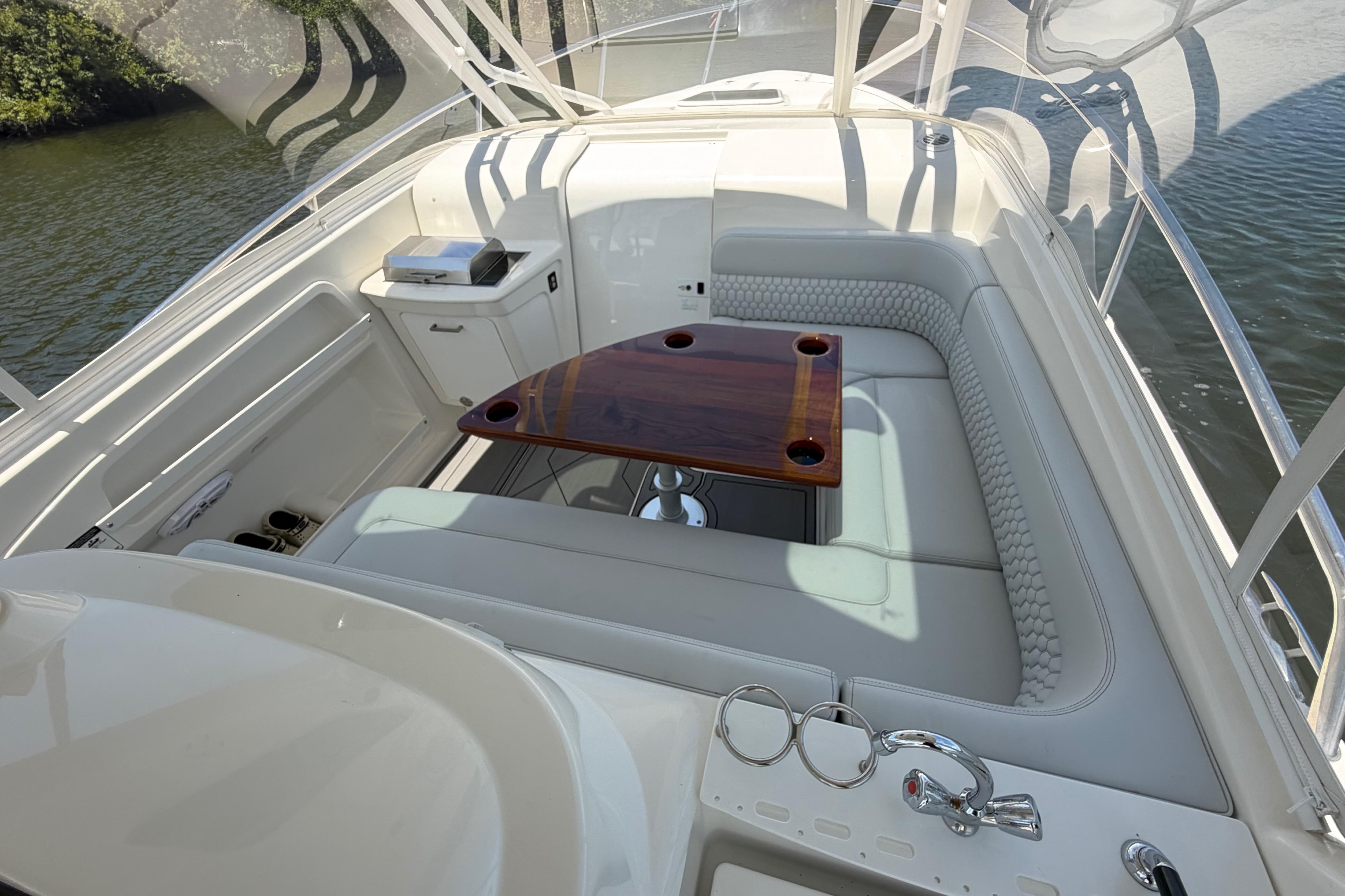 Luxurious seating area on a 2009 Everglades 350LX boat with elegant wood table.