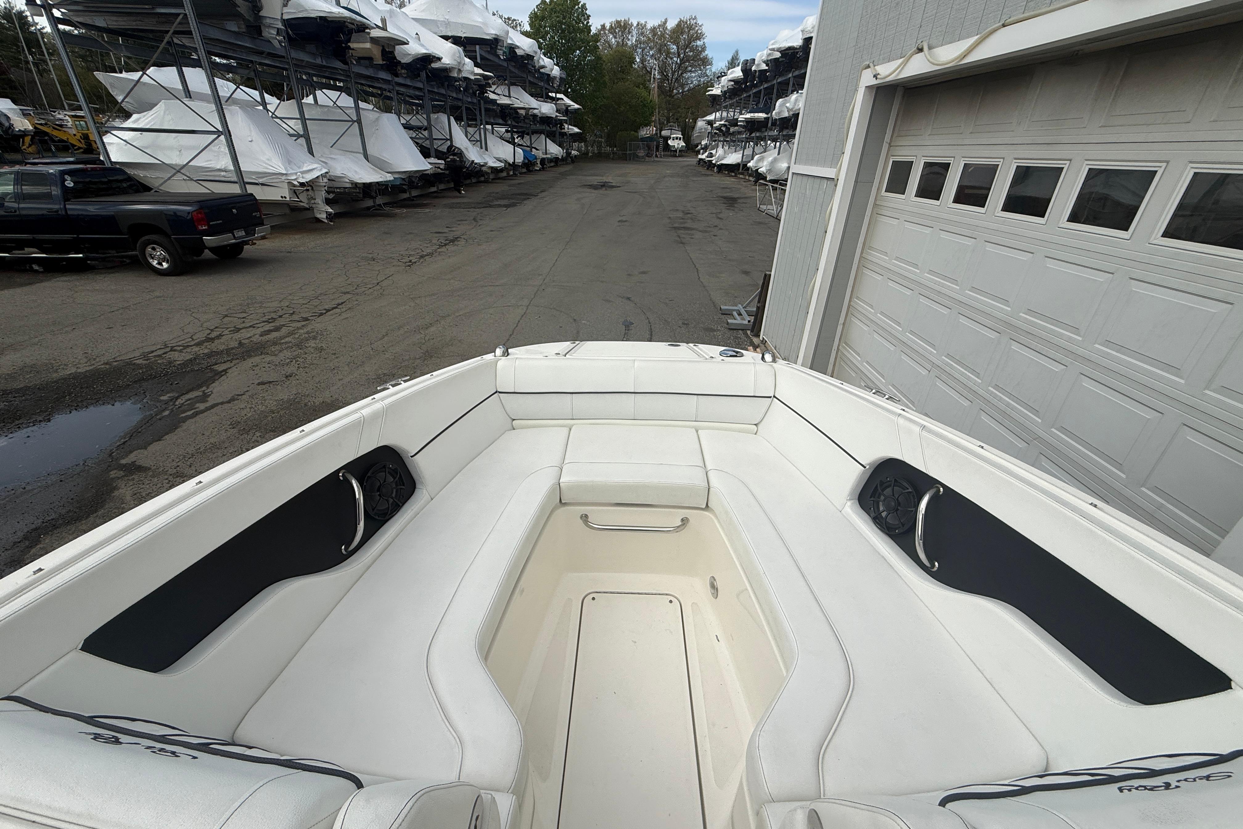 2015 Sea Ray 240 Sundeck boat interior with white seating, docked near storage facility.