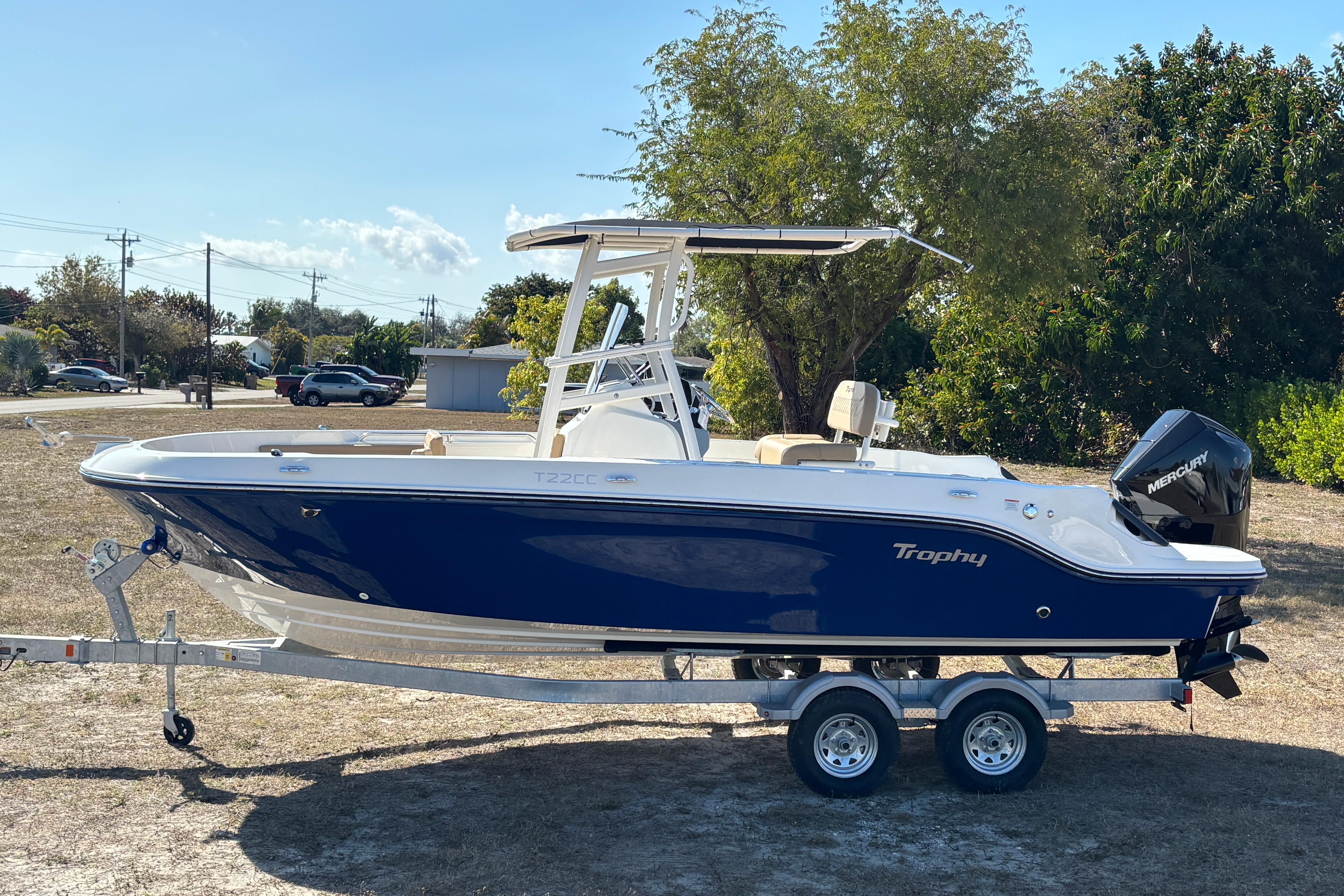 2026 Bayliner Trophy T22CC boat on trailer, parked outdoors, side view.