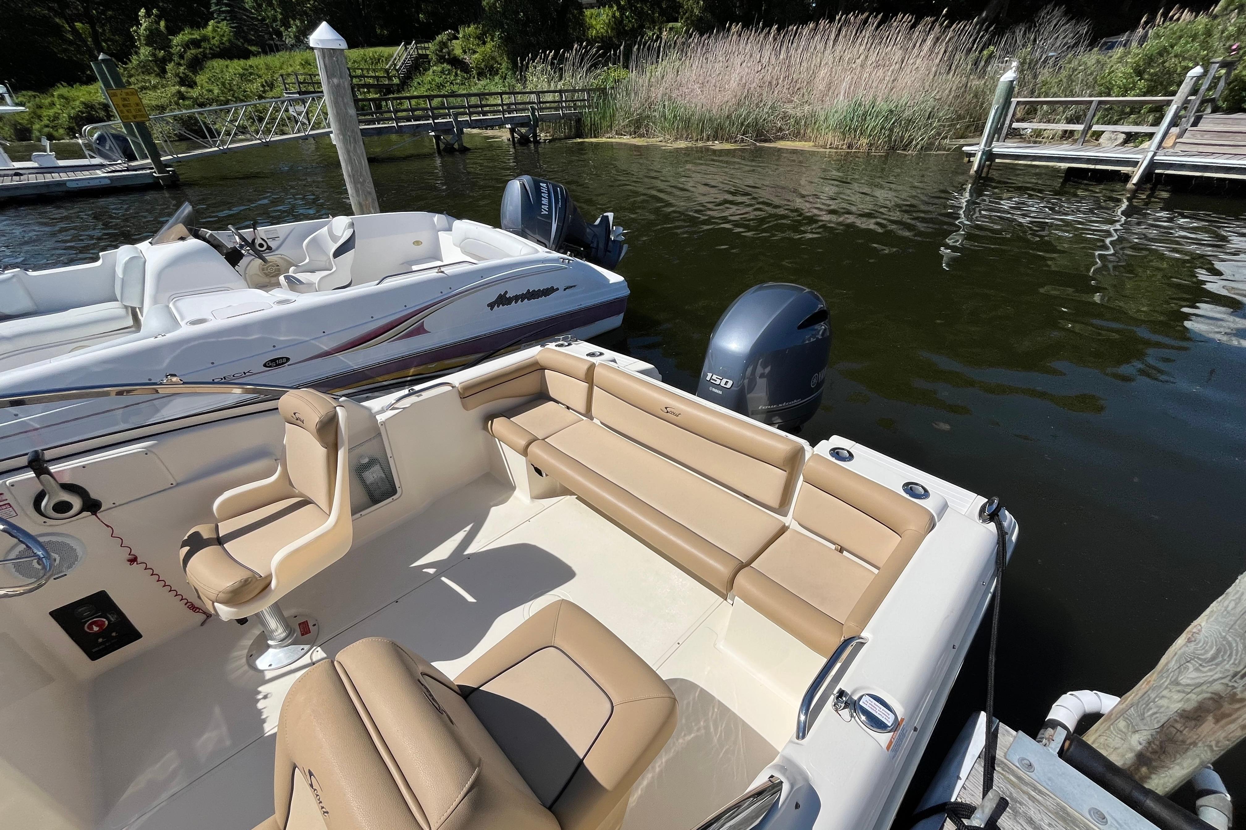 2017 Scout 210 Dorado boat docked, featuring tan seating and Yamaha outboard motor.