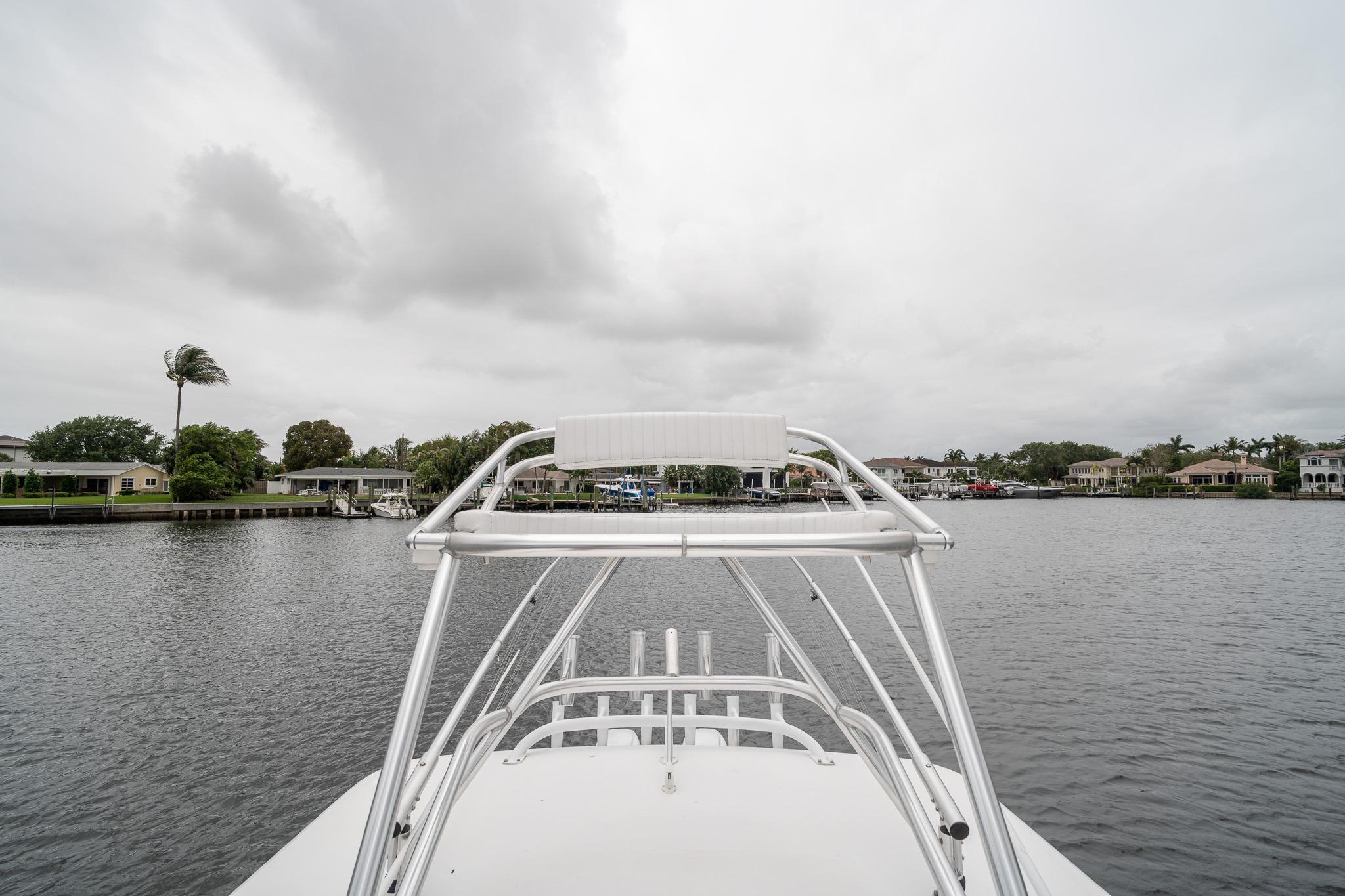 2006 Venture Center Console boat on a calm river with cloudy skies.