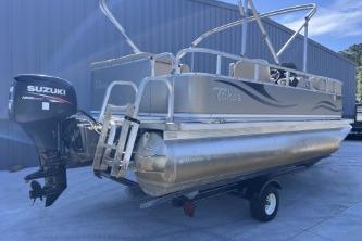 2012 Avalon Tahoe pontoon boat with Suzuki outboard motor, parked on trailer.