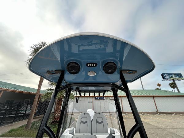 2024 Sea Pro 250 DLX boat with blue T-top and dual speakers.