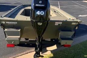 2026 Tracker Grizzly 1654 T Sportsman boat with Mercury 40 engine, parked on pavement.