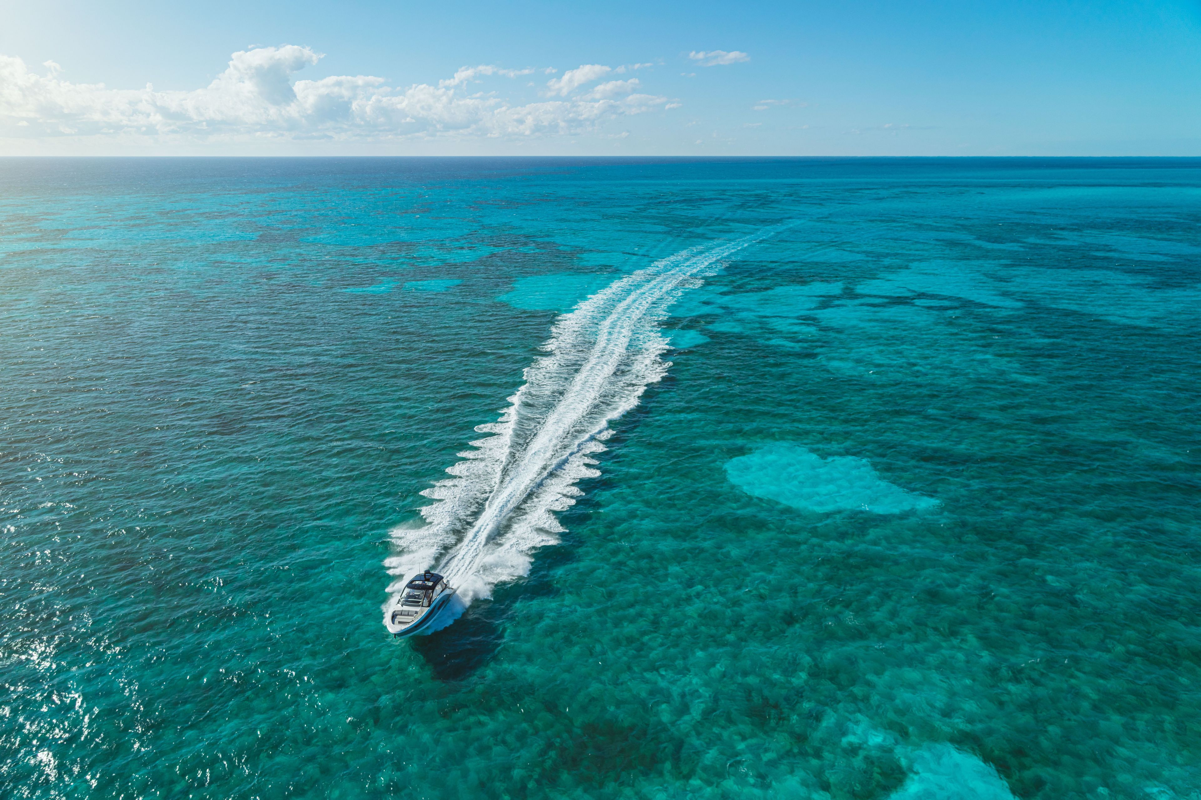 A Sea Ray Sundancer 370 Outboard speeds across the turquoise sea.