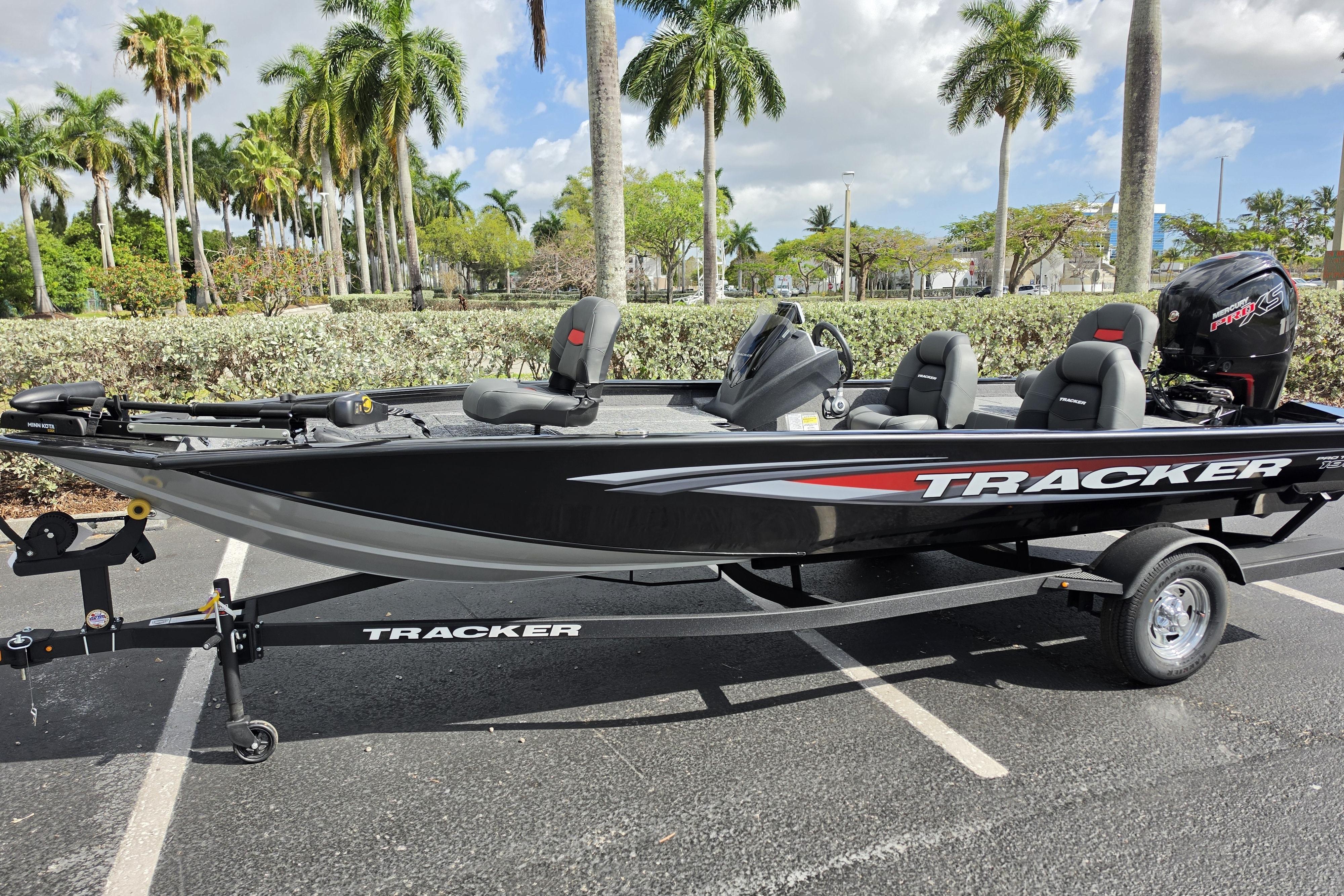 2026 Tracker Pro Team 190 boat on trailer, parked with palm trees in background.