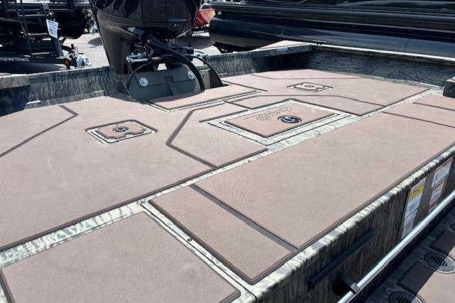 2026 Tracker Grizzly 2072 CC boat deck with storage compartments and motor.