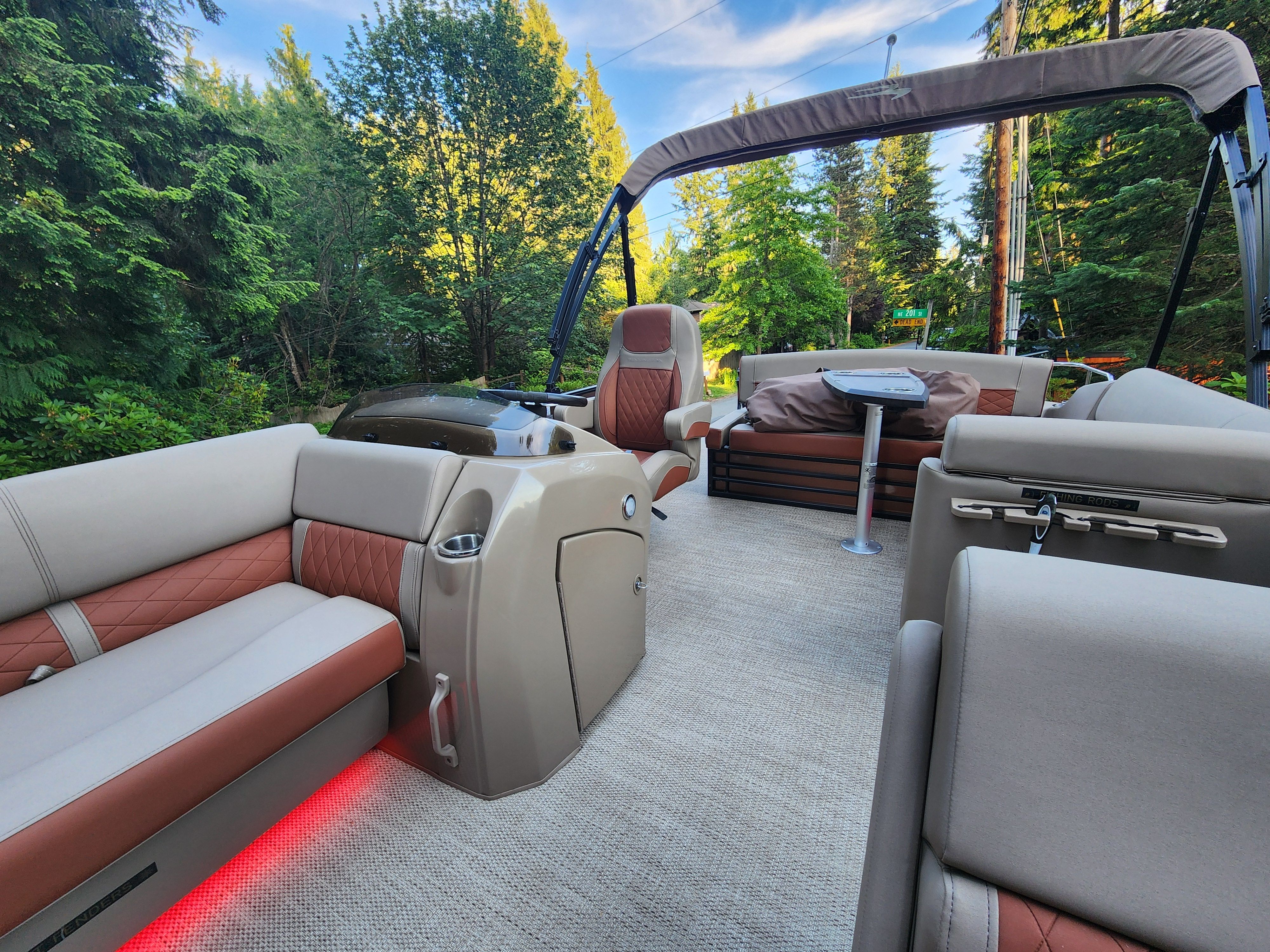 The image shows the interior of a Bennington 22 LSB pontoon boat with luxurious seating and a table.