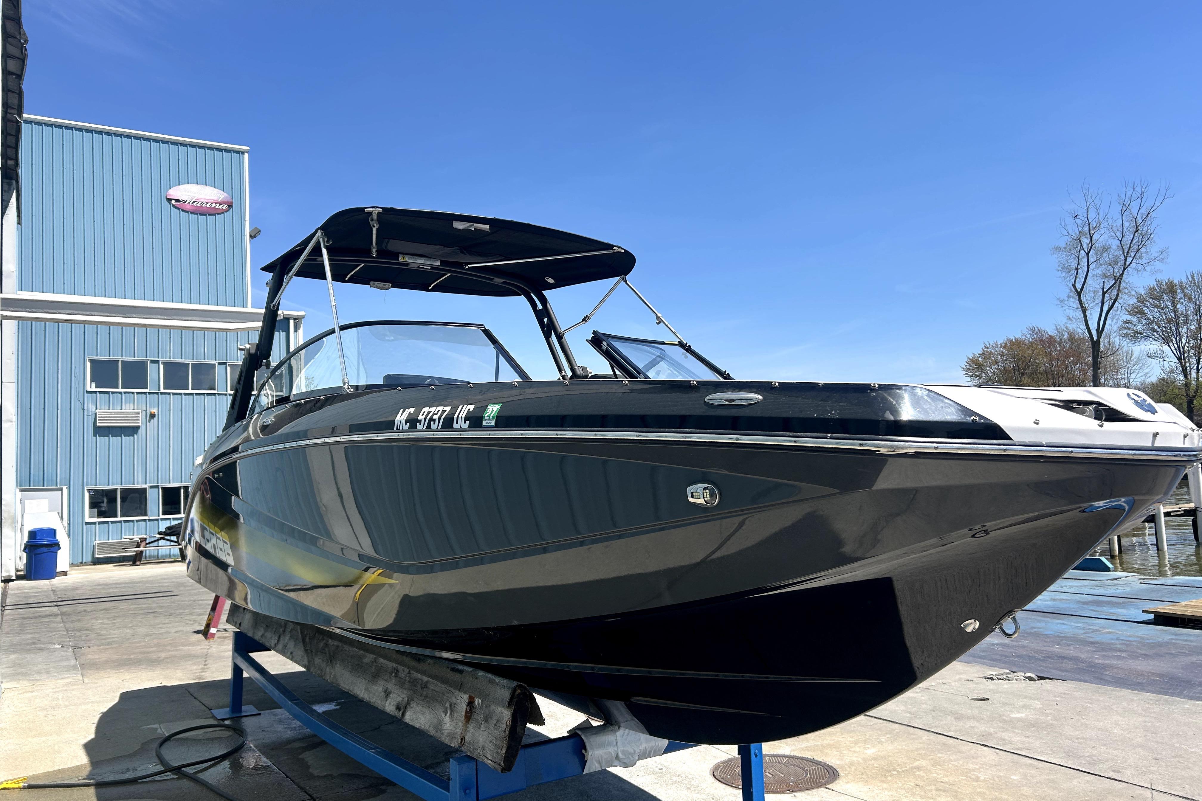 2017 Scarab 255 H.O. Impulse boat on lift, blue sky background.