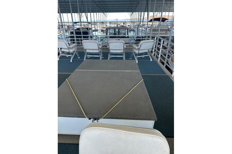 2008 Destination Yachts 45X14 houseboat deck with chairs under covered marina.