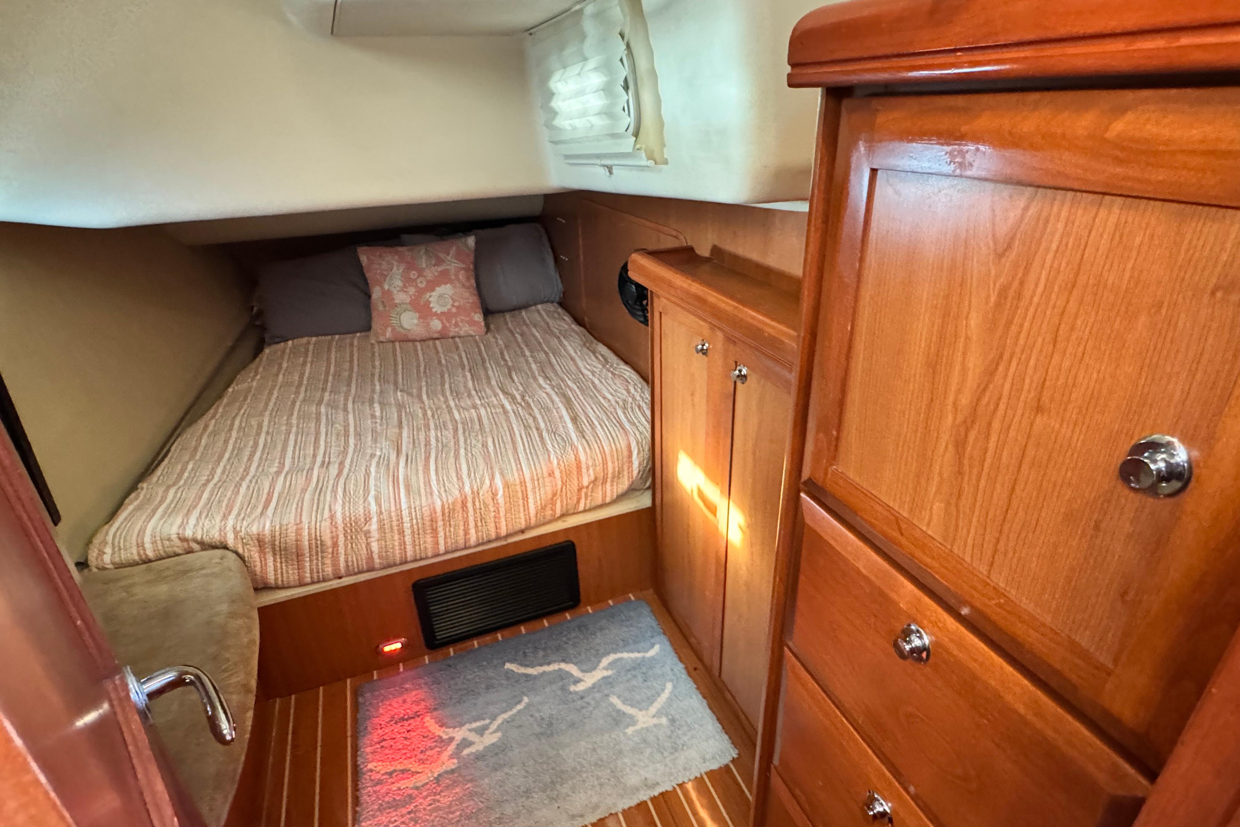 Cozy cabin interior of 2008 Hunter 49 yacht with wooden cabinetry and comfortable bedding.