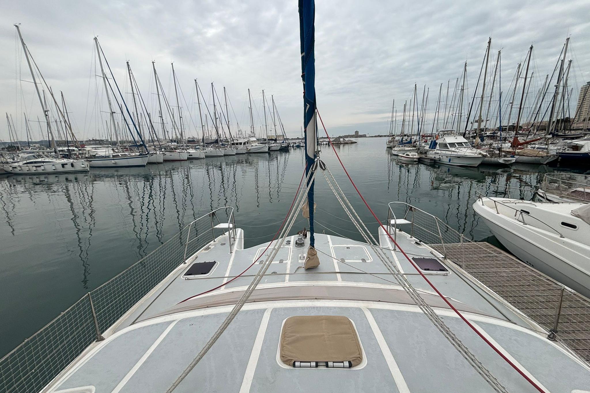 1998 Prout 38 catamaran docked in a marina with numerous sailboats.