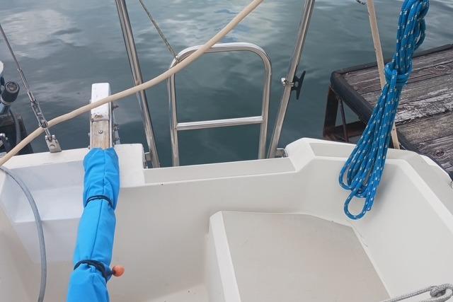 1989 O'Day 272 sailboat stern with blue rope and dock in background.