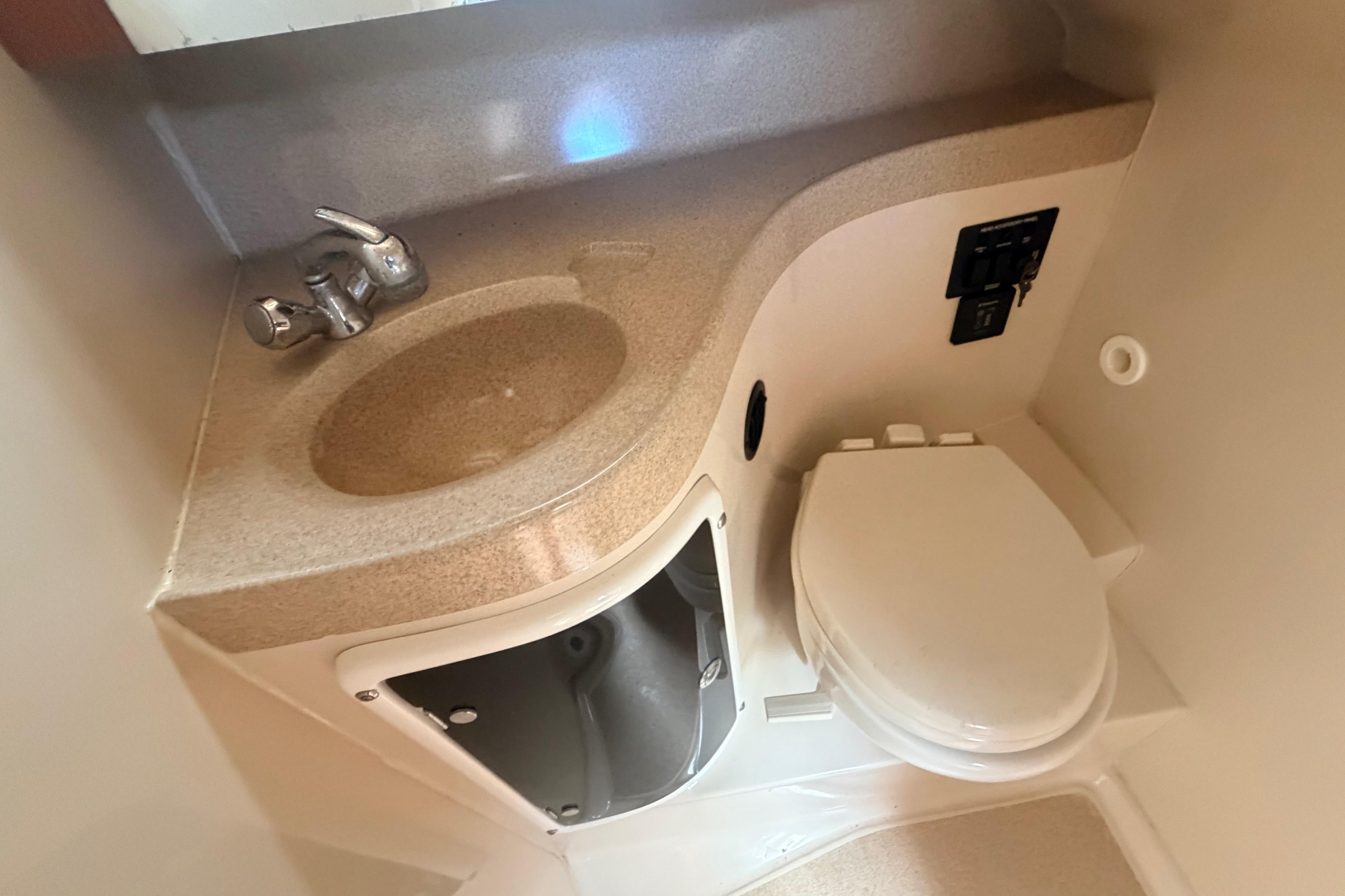 2015 Wellcraft 290 Coastal boat bathroom with sink and toilet.