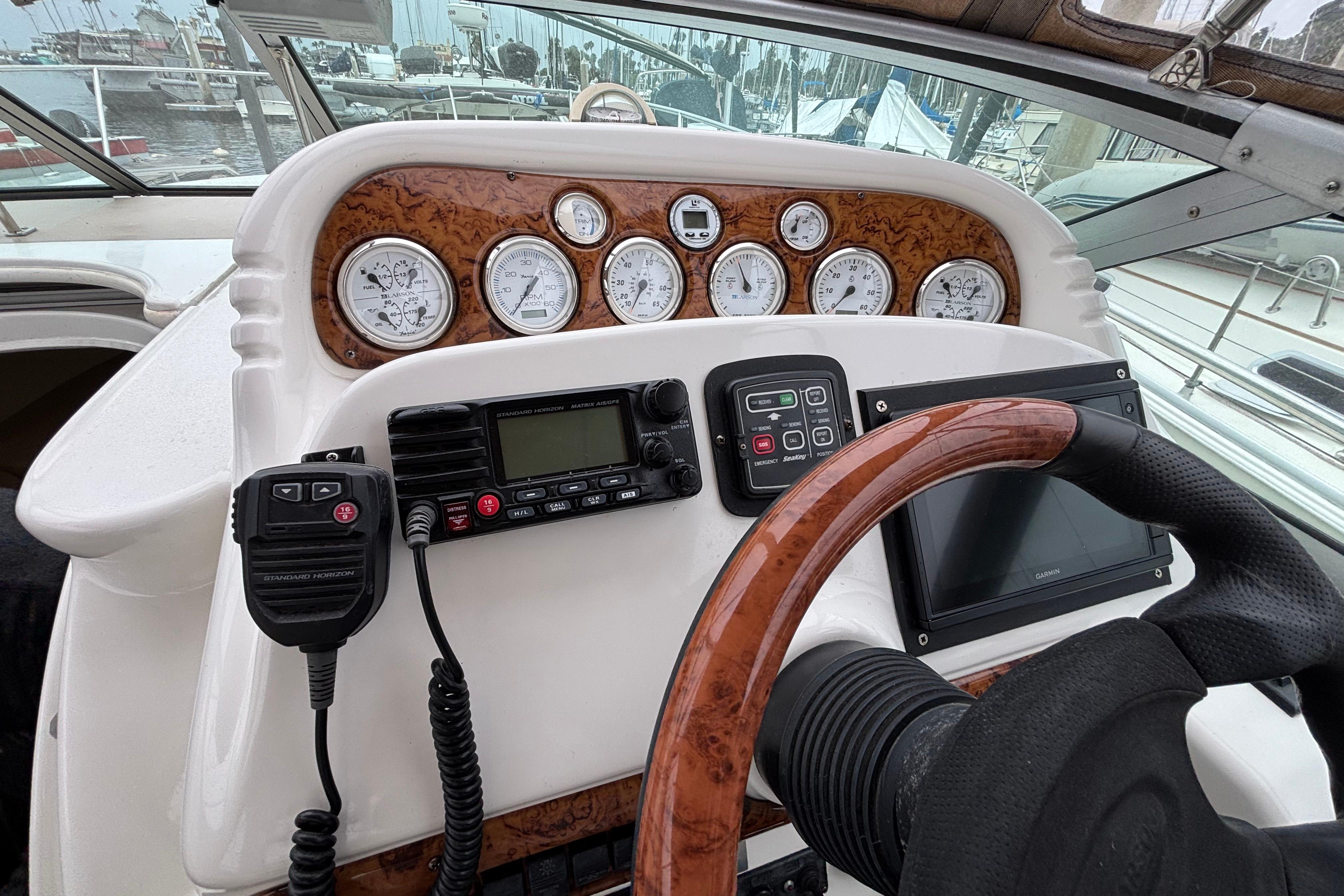 Helm of 2004 Larson 310 boat with gauges, radio, and steering wheel.