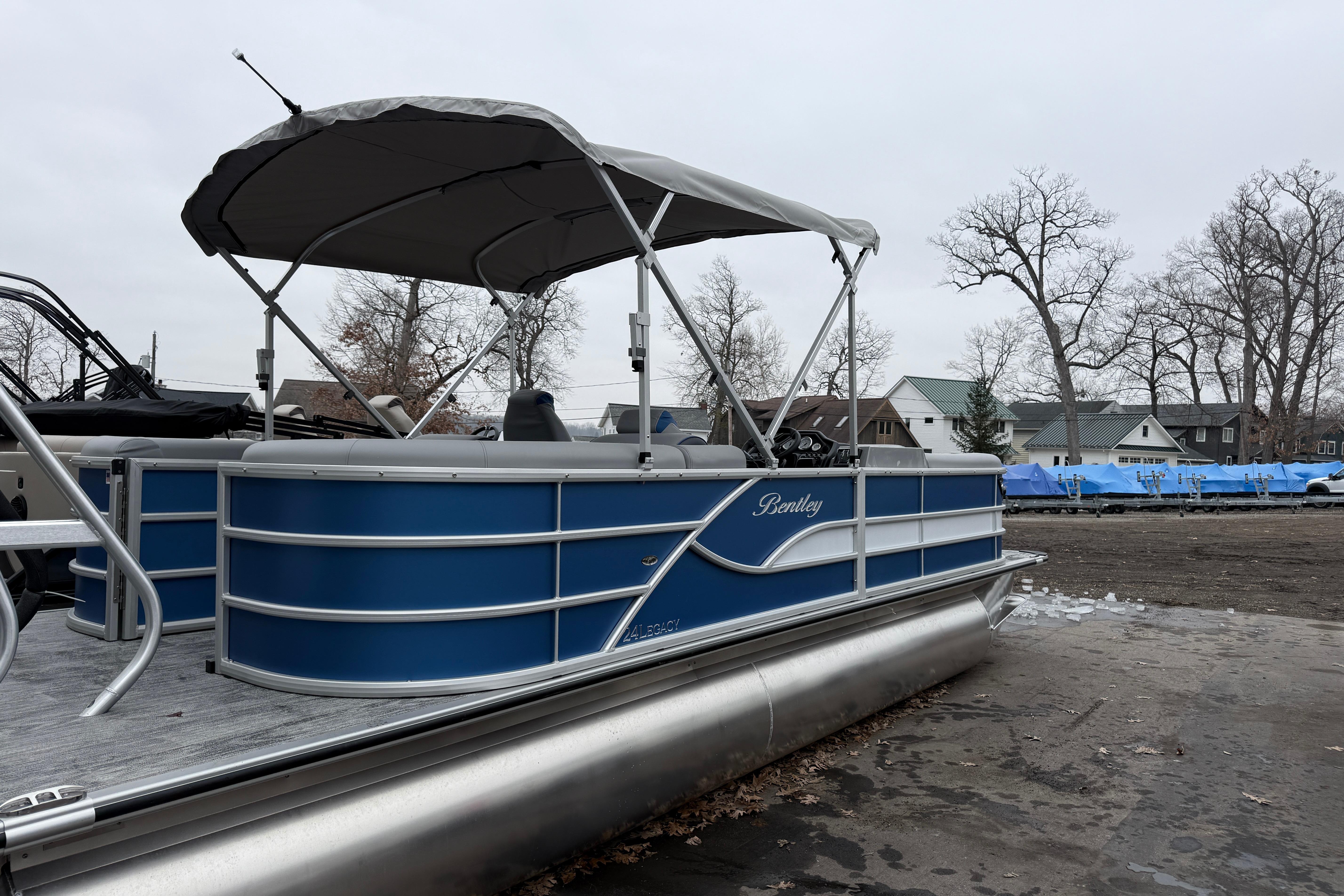 2026 Bentley Pontoons Legacy 240 Navigator Ext on display, featuring blue exterior and canopy.
