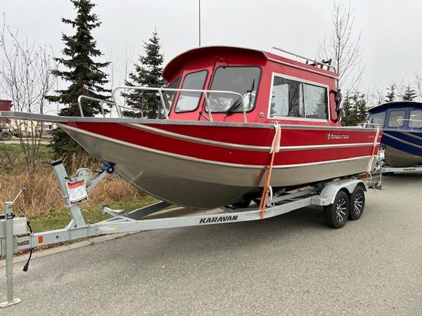 2024 Spartan 220 Maximus boat in red on a Karavan trailer, parked outdoors.