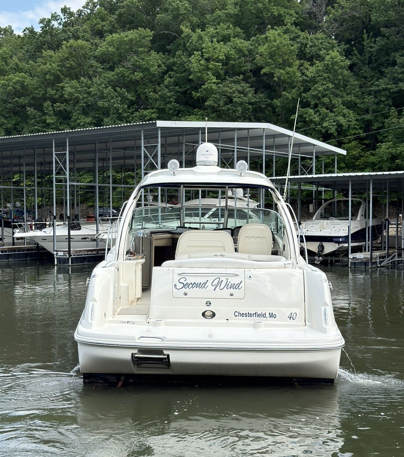 A 2007 Sea Ray 40 Sundancer is docked on the water near a covered dock.