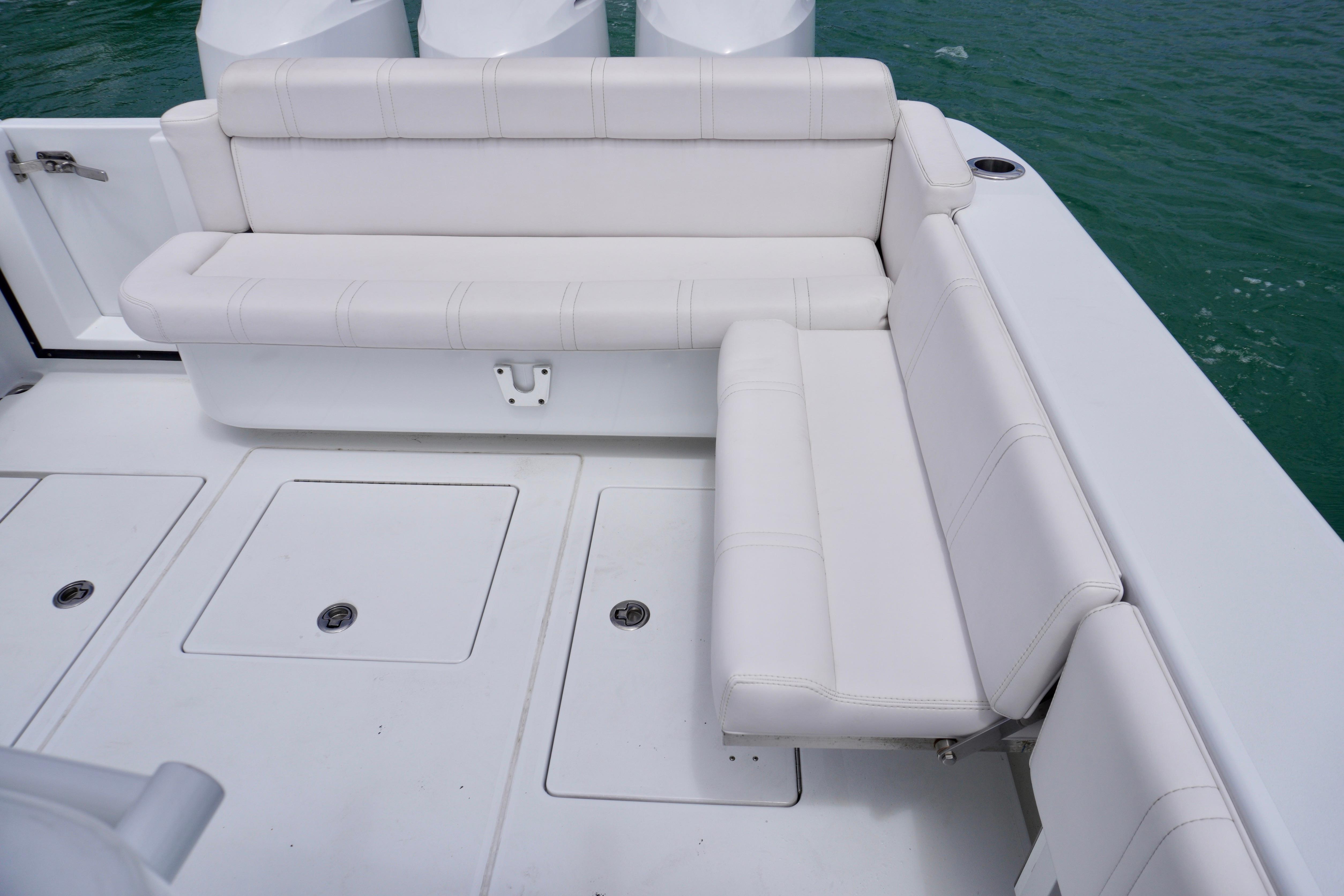 White seating area on 2013 Contender 35 LS boat, with storage compartments and ocean view.
