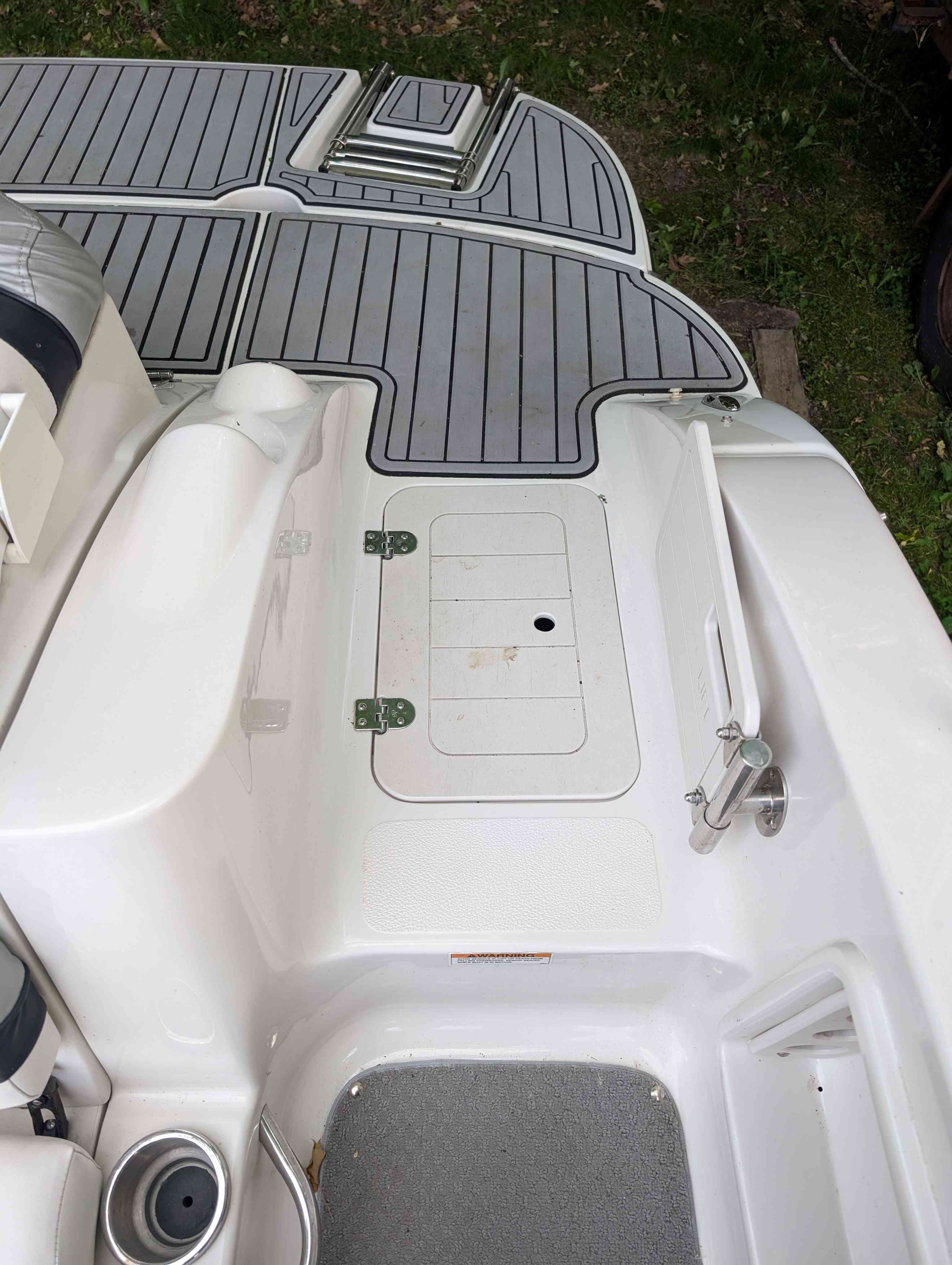 2015 Starcraft 2000 boat with gray deck and storage compartment.
