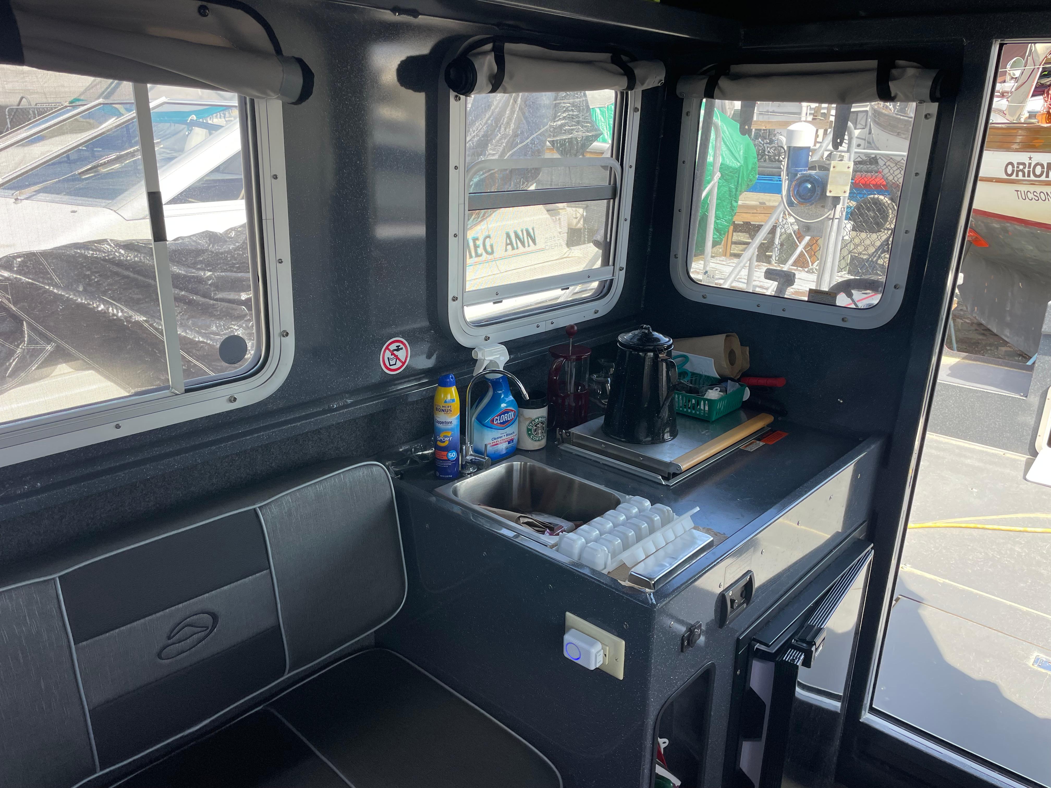 Interior of a 2018 Duckworth 28 Offshore boat with kitchenette and seating area.