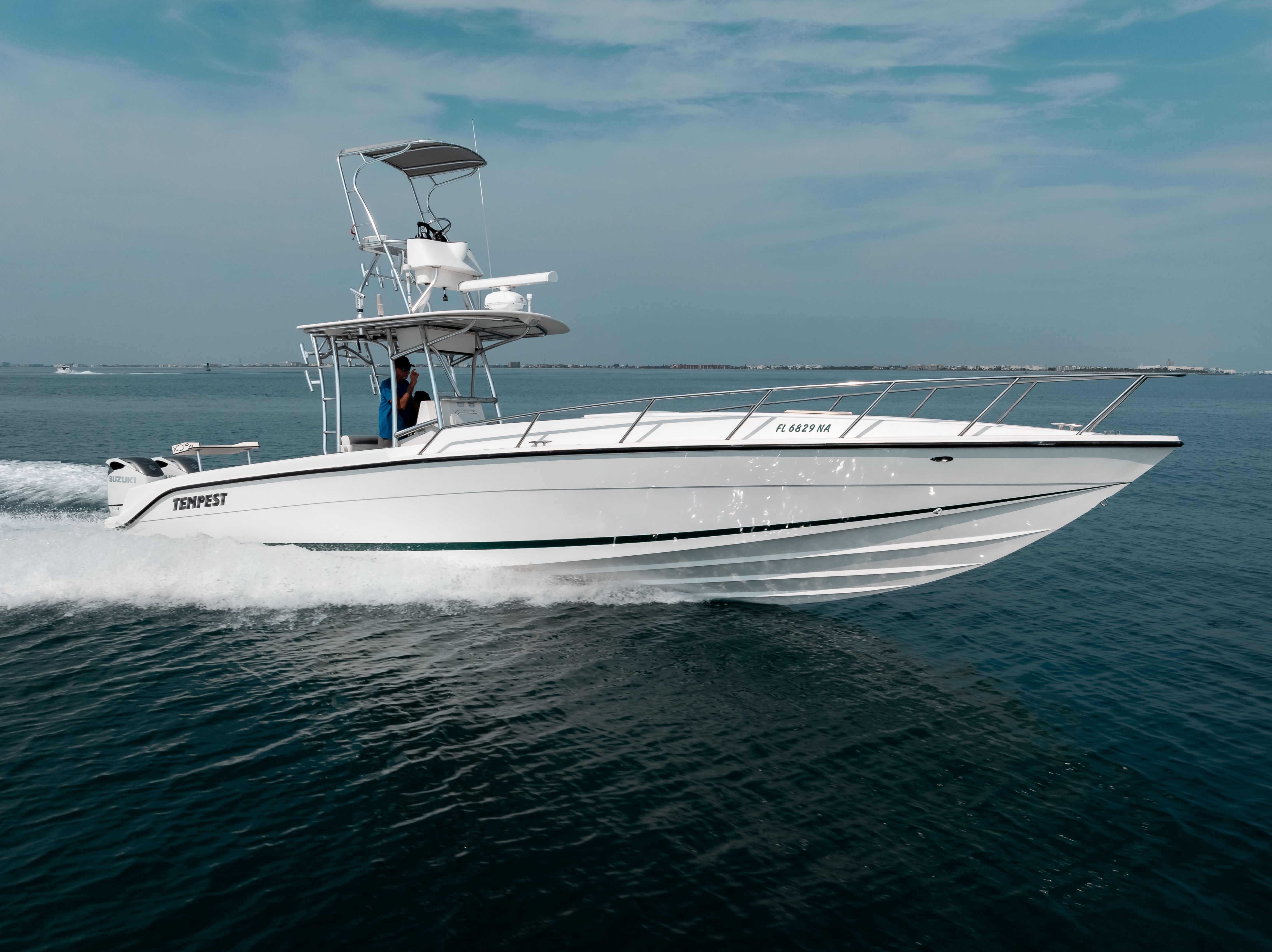 A 2006 Tempest Offshore 40 speeds across the water. It features an elevated helm.