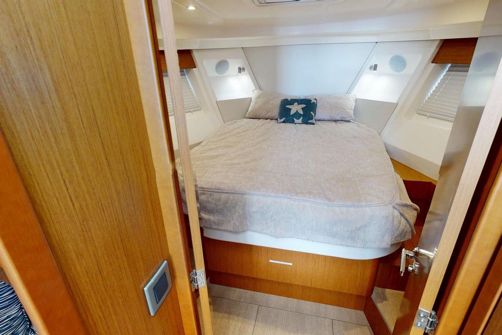 2021 Beneteau Swift Trawler 35 cabin with cozy bed and nautical decor.