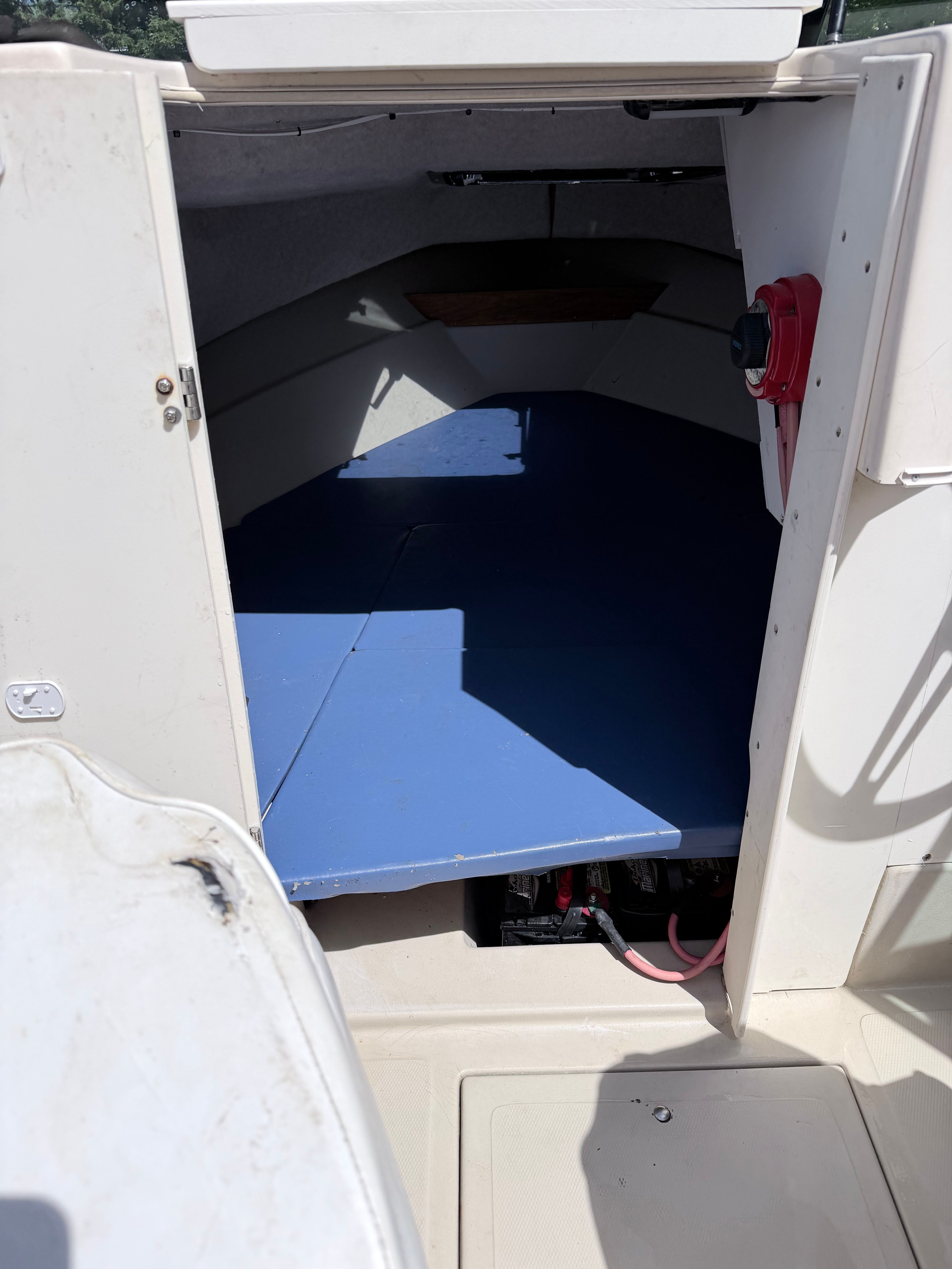 Interior view of a 1993 Arima Sea Explorer 1511 with blue flooring and storage space.