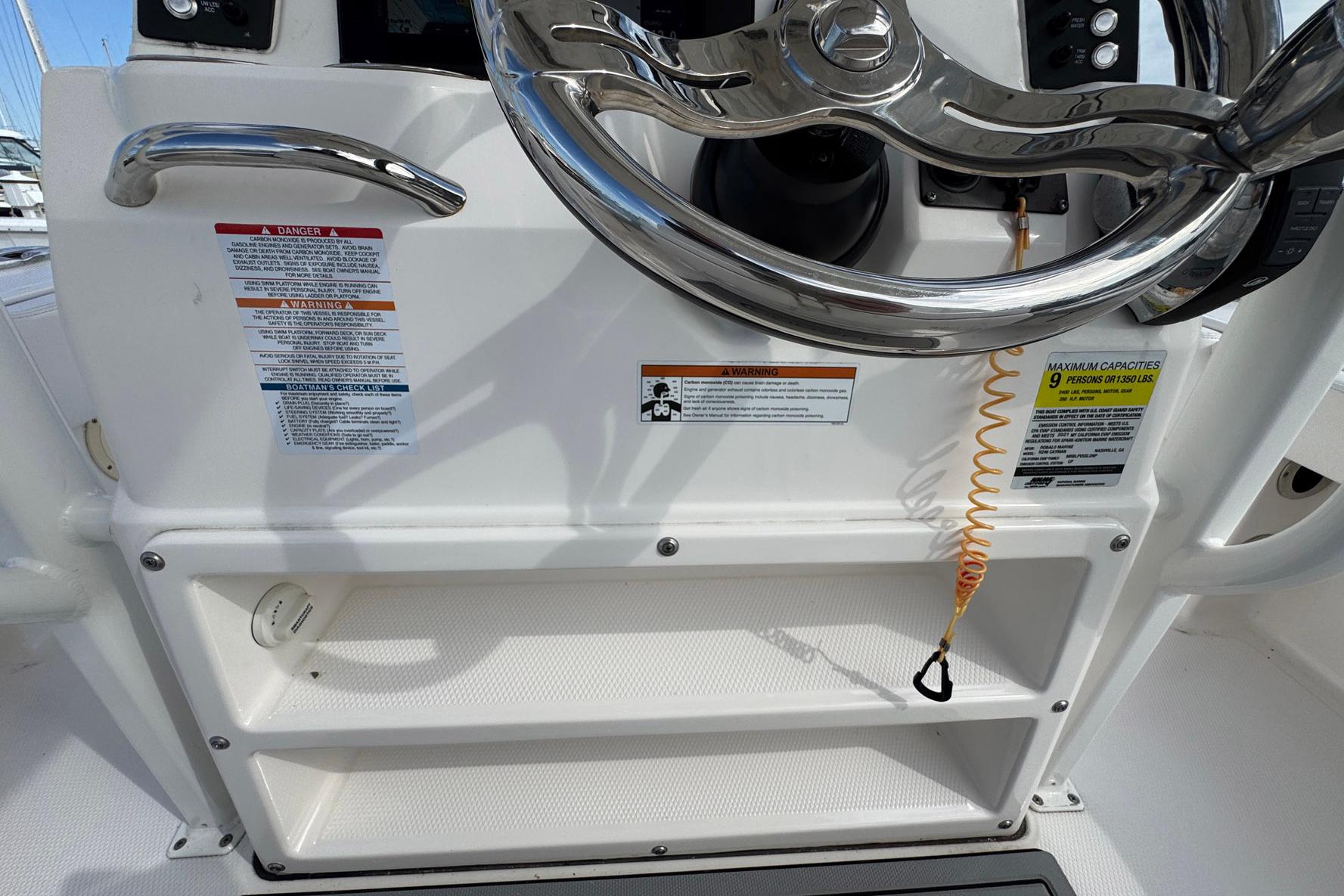 2021 Robalo 246 Cayman boat steering console with safety warnings and capacity details.