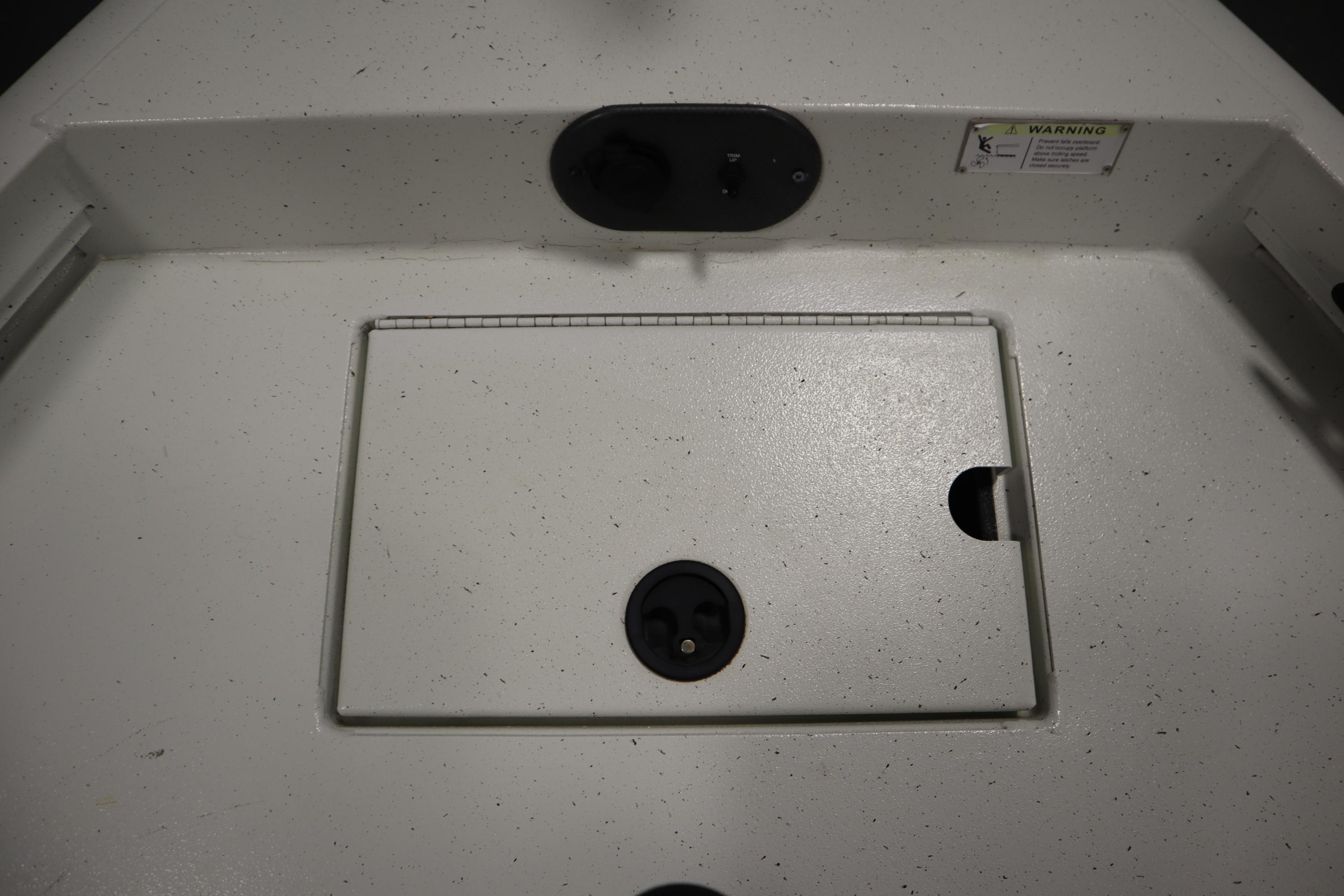 2022 Crestliner 2200 CC boat deck with storage compartment and warning label.