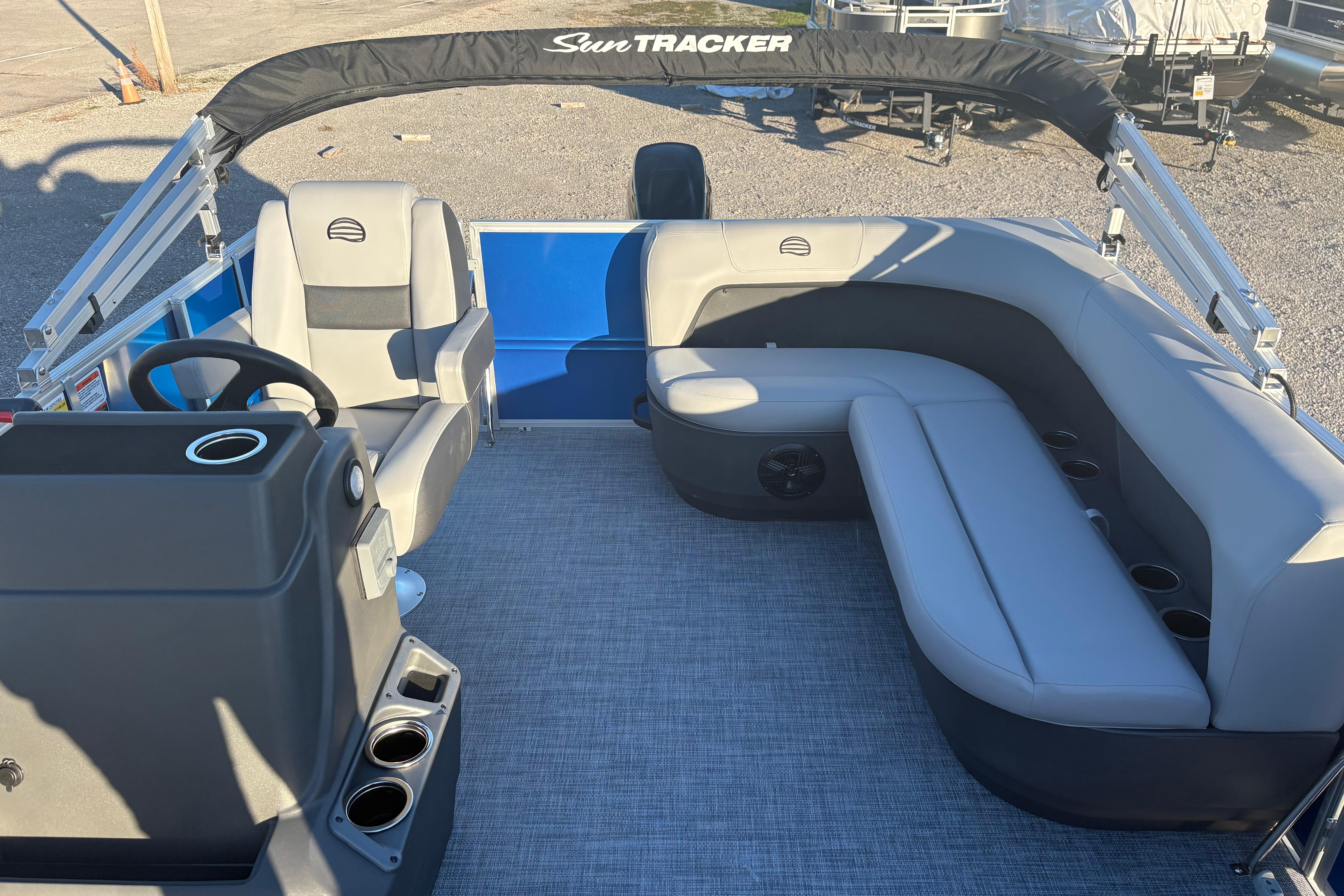 2026 Sun Tracker Party Barge 16 DLX interior with gray seating and steering console.