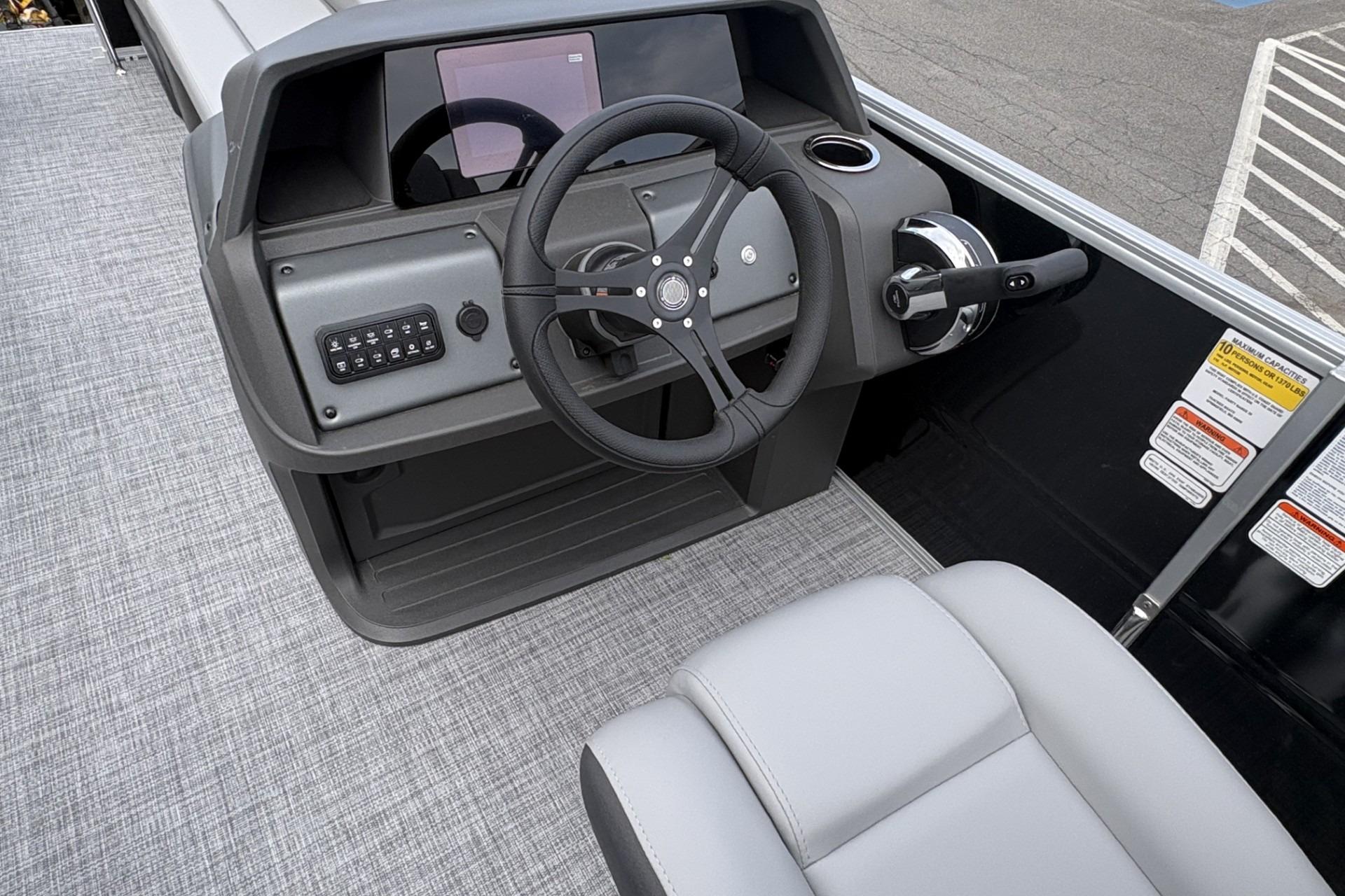 2026 Sun Tracker Party Barge 20 DLX helm with steering wheel and control panel.