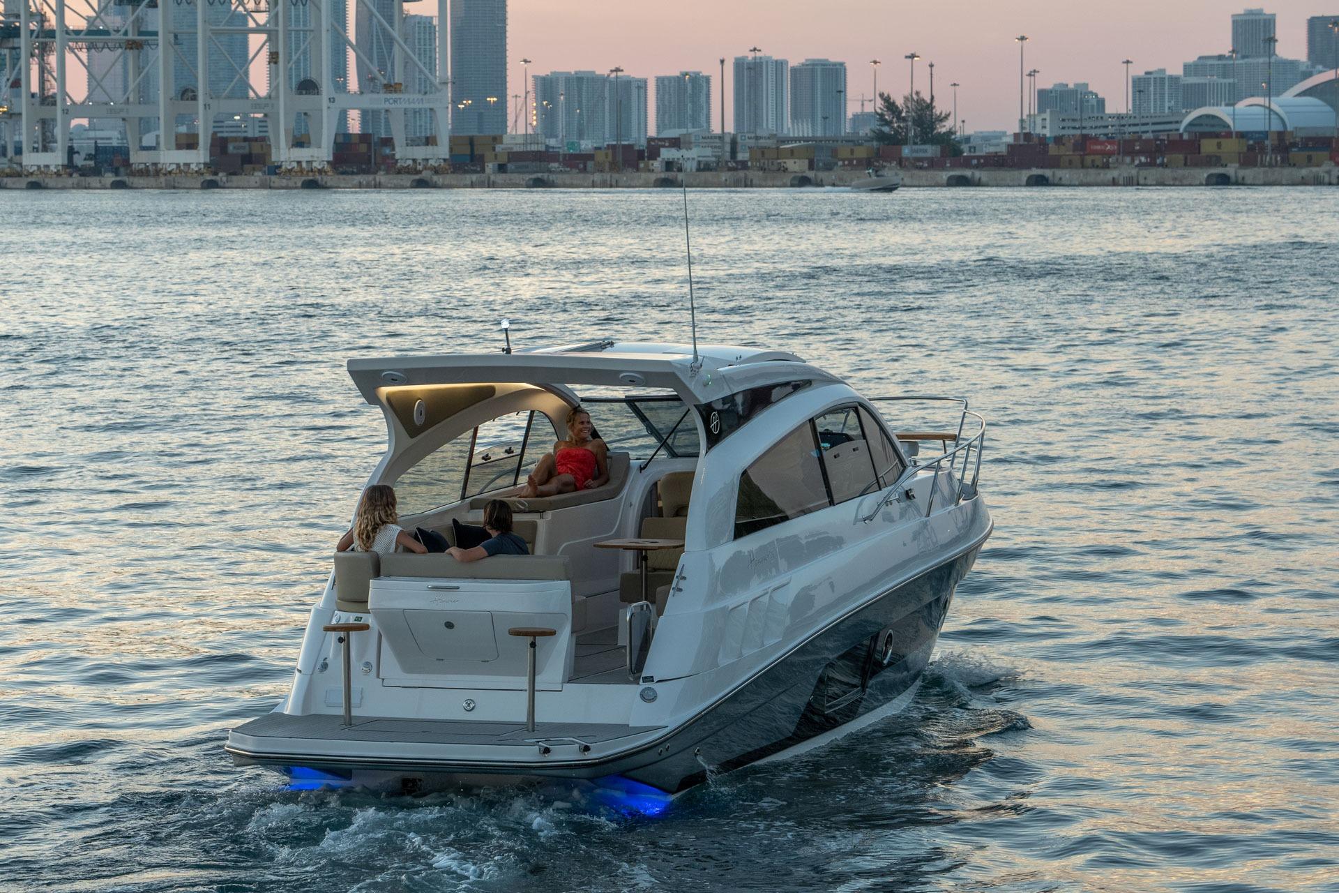 Luxury Hanover 375 yacht cruising near city skyline at sunset, 2026 model.