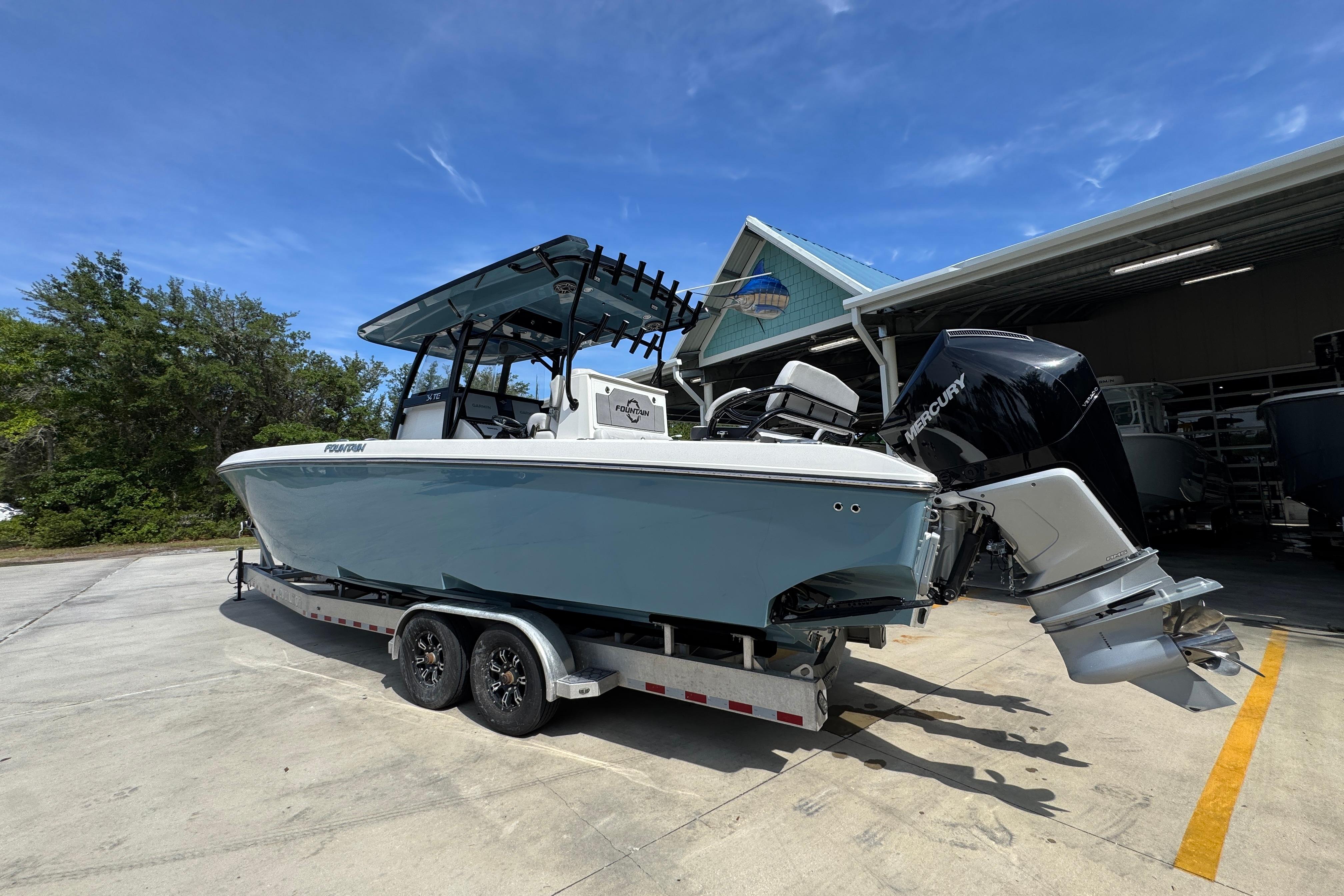 2023 Fountain 34 Tournament Edition boat on trailer, parked outdoors under clear blue sky.
