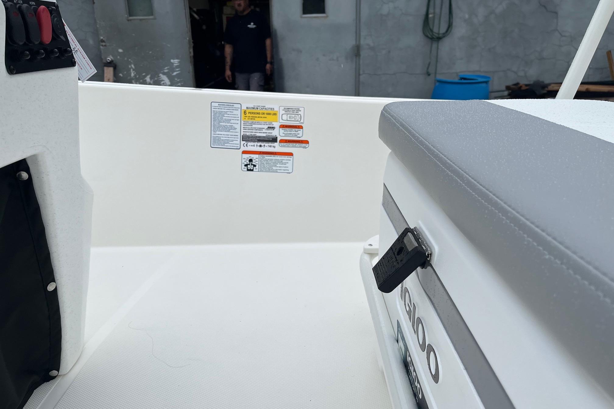 Interior view of 2026 Mako Pro Skiff 17 CC boat with seating and control panel.