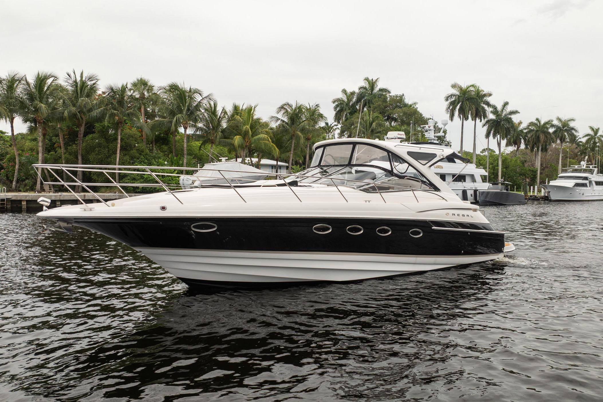 2008 Regal Commodore 4460 yacht on water, surrounded by palm trees and other boats.